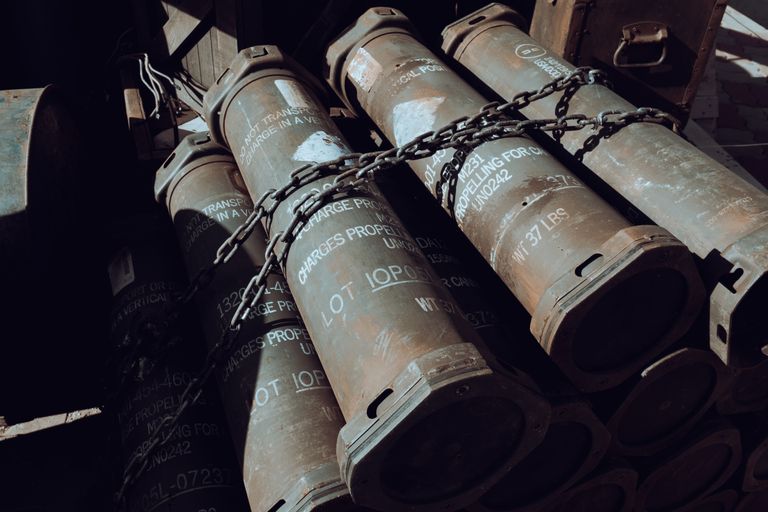 Close-up of chained military missile containers in a warehouse.
