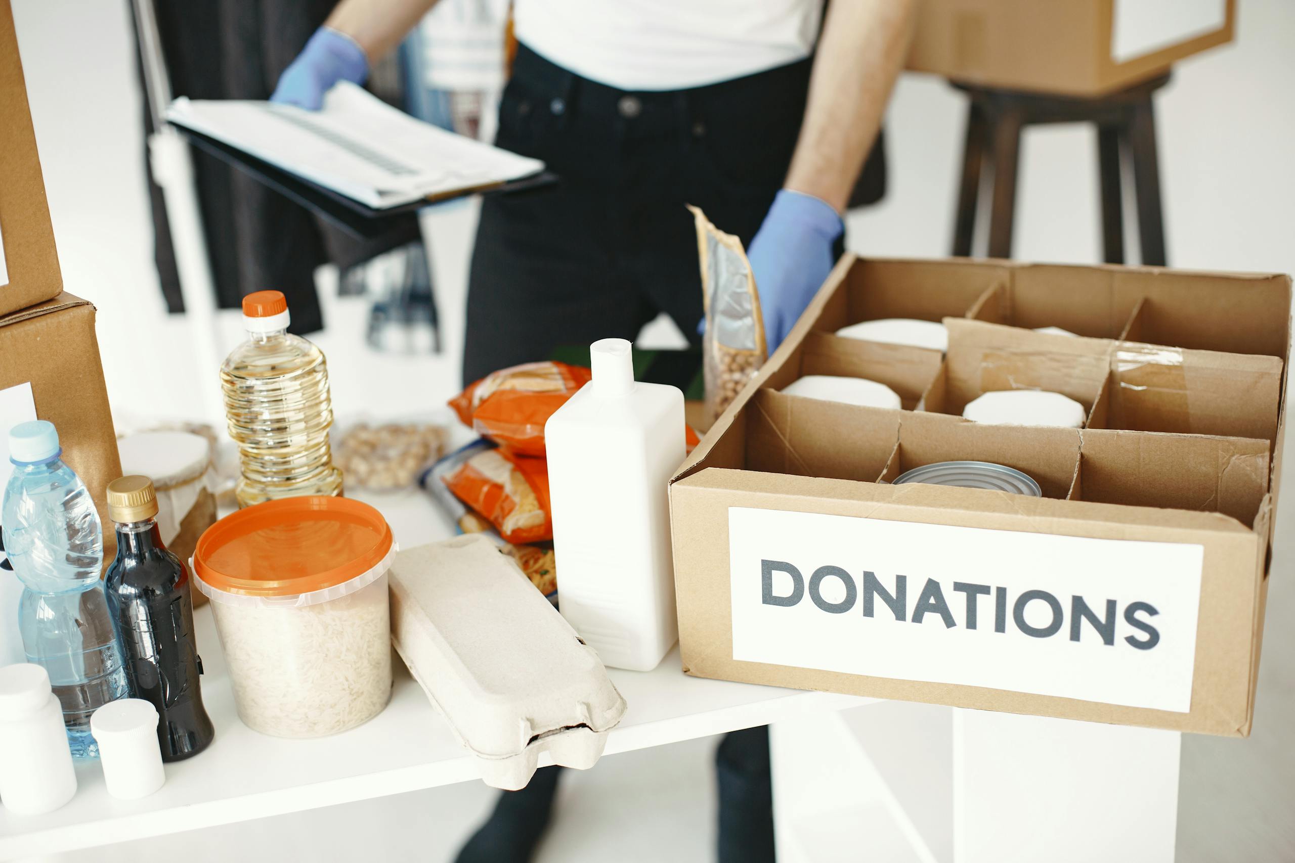 Close-up of donation box with various food items and supplies for community support.