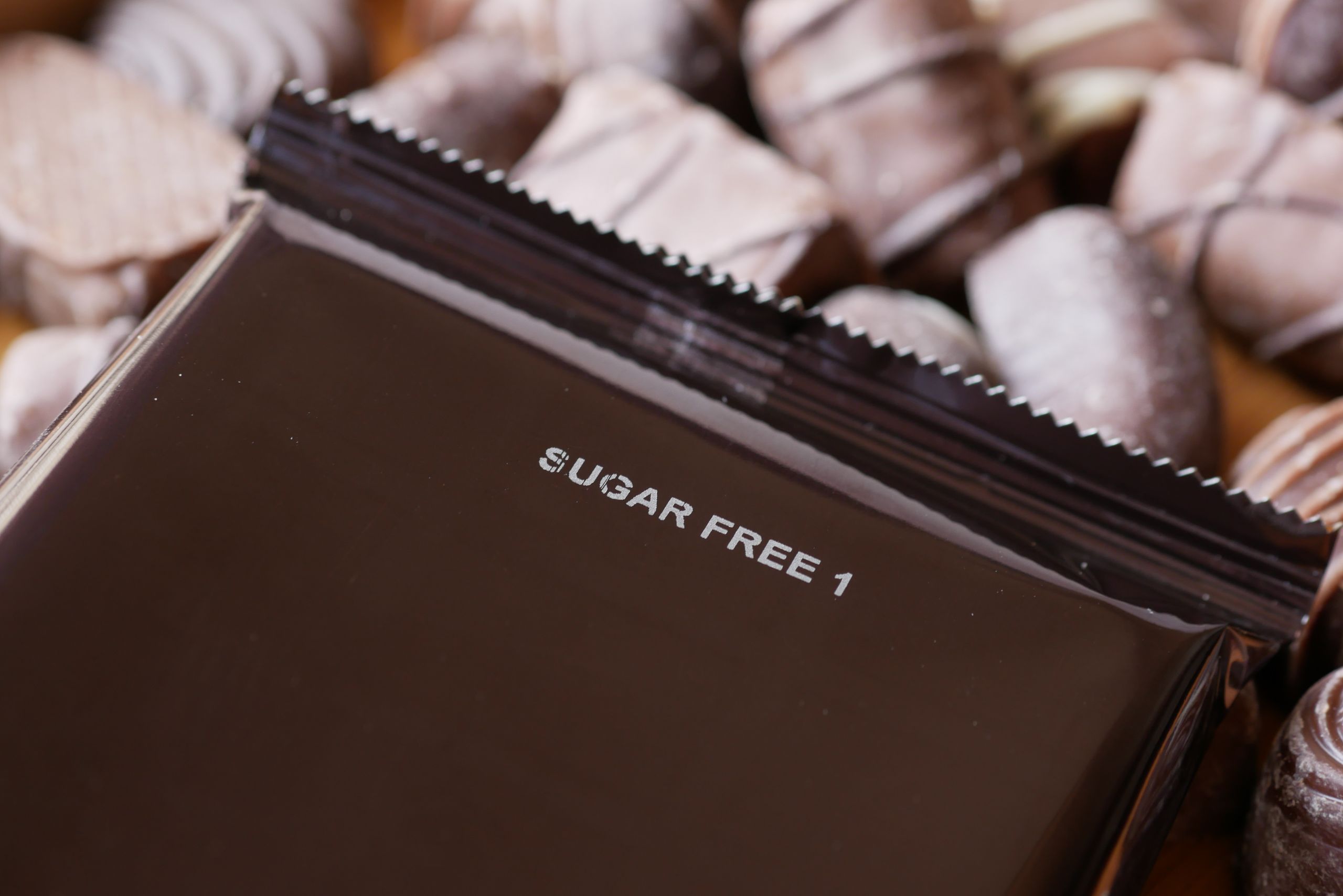 Close-up of sugar-free chocolate candies with a focus on a wrapped piece.