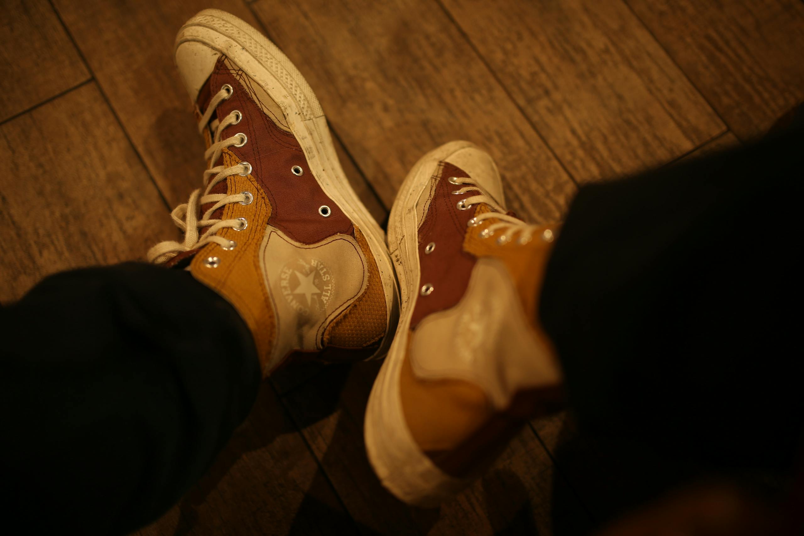 Close-up of vintage high top sneakers with a worn look on a wooden floor.