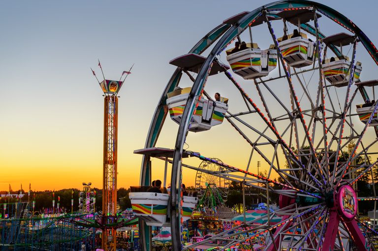 Colorful Ferris wheel at Boise amusement park during sunset, capturing vibrant lights and fun atmosphere.
