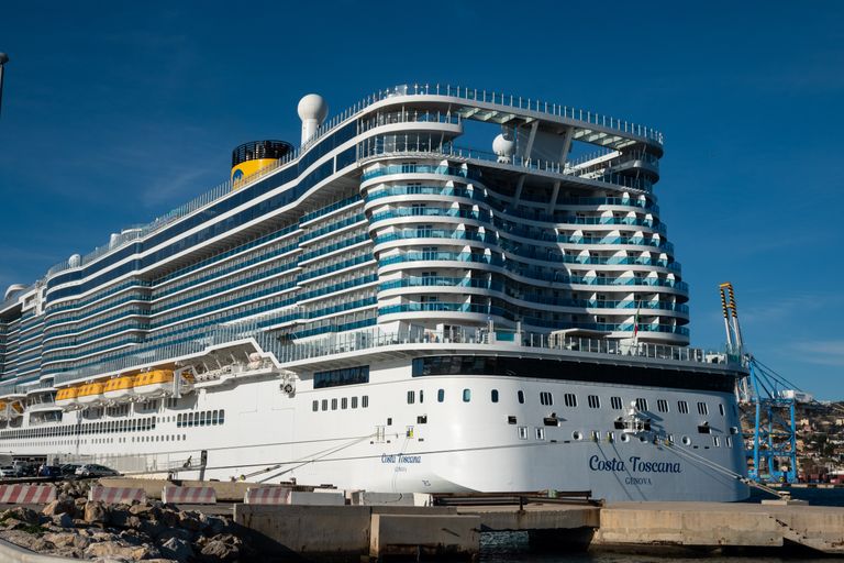 Costa Toscana cruise ship docked at a sunny harbor, showcasing modern luxury.