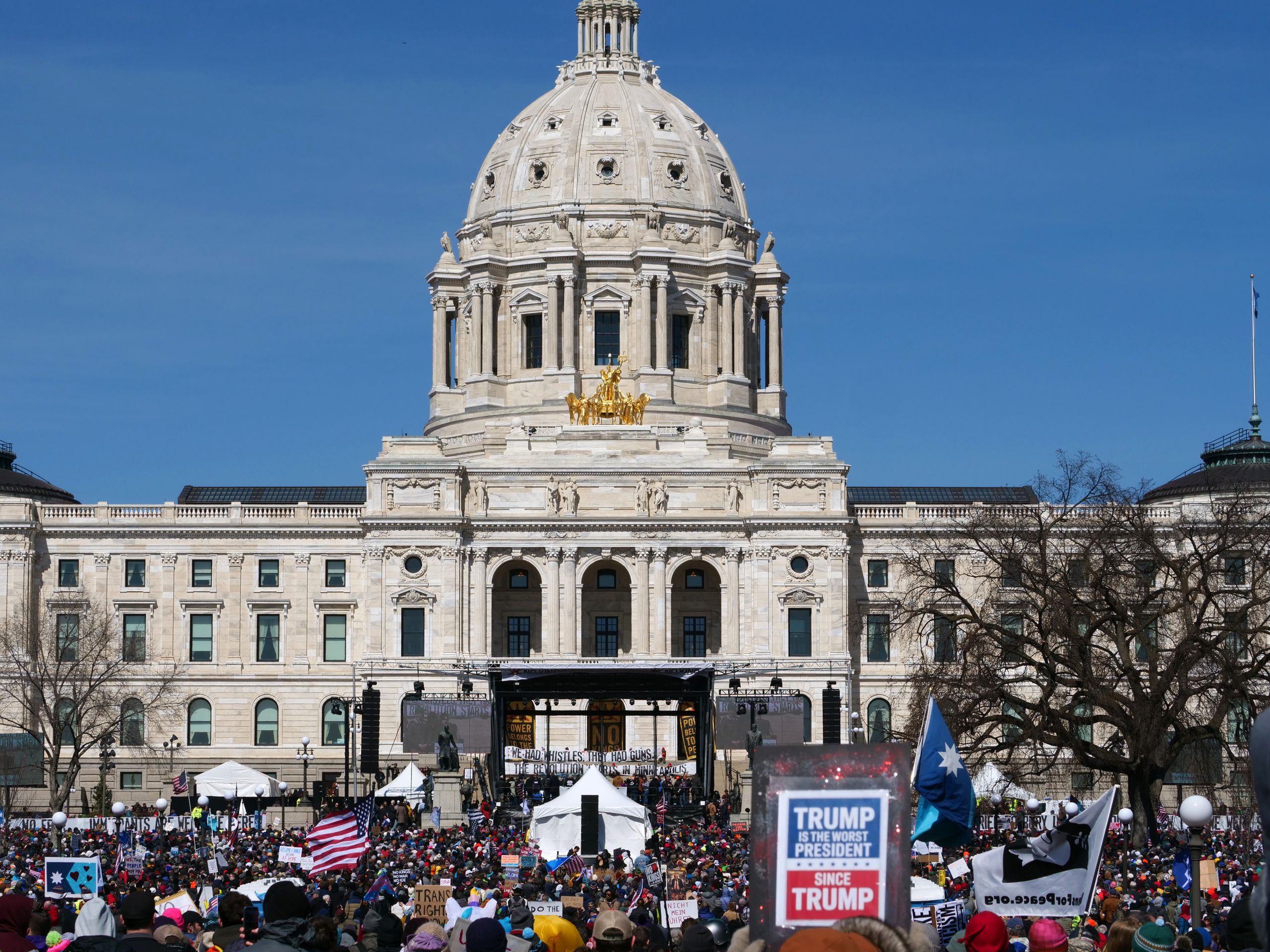 A crowd gathers at the Minnesota State Capitol for protest in springtime.
