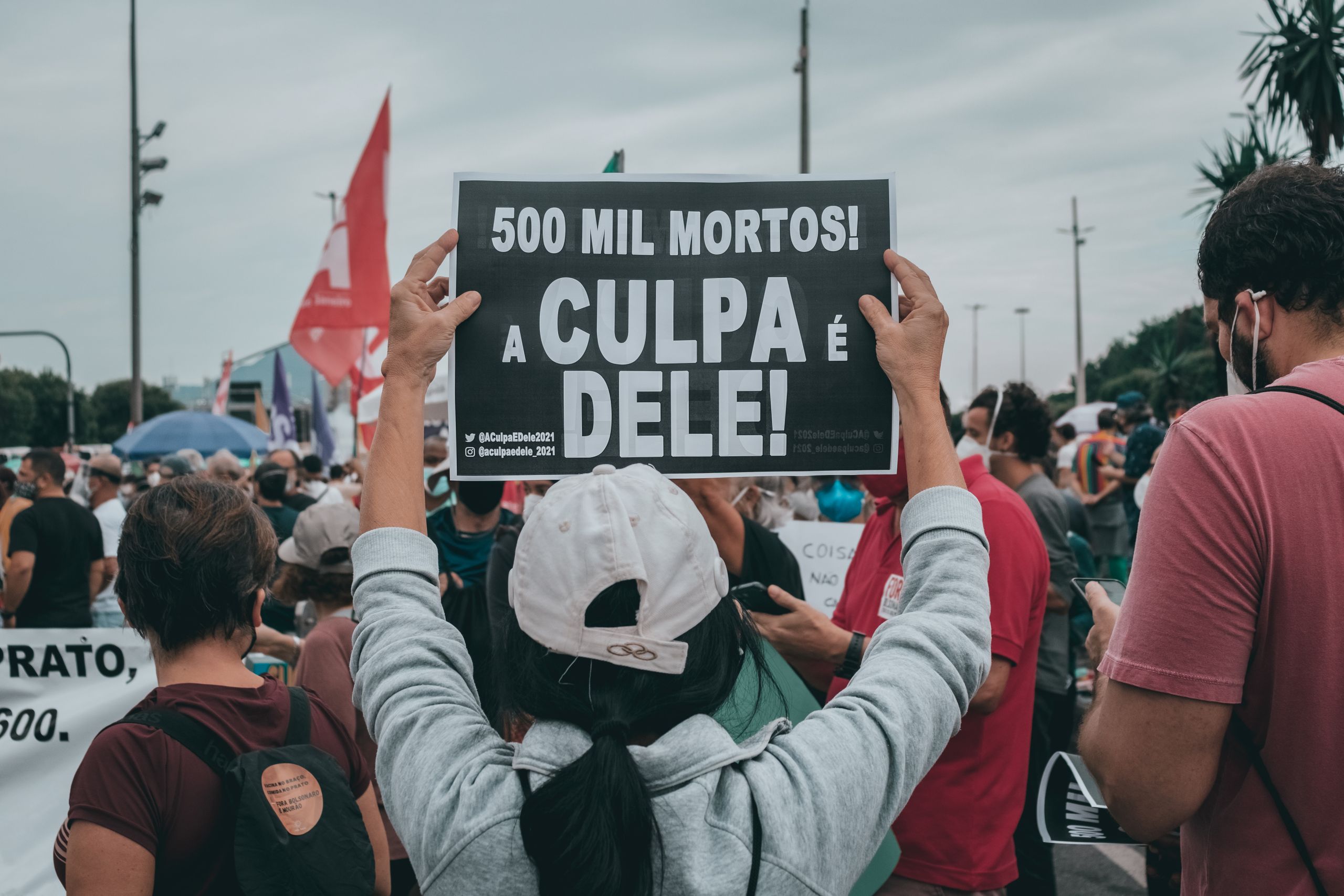 Crowds gather in Rio de Janeiro, Brazil, holding protest signs demanding political change.