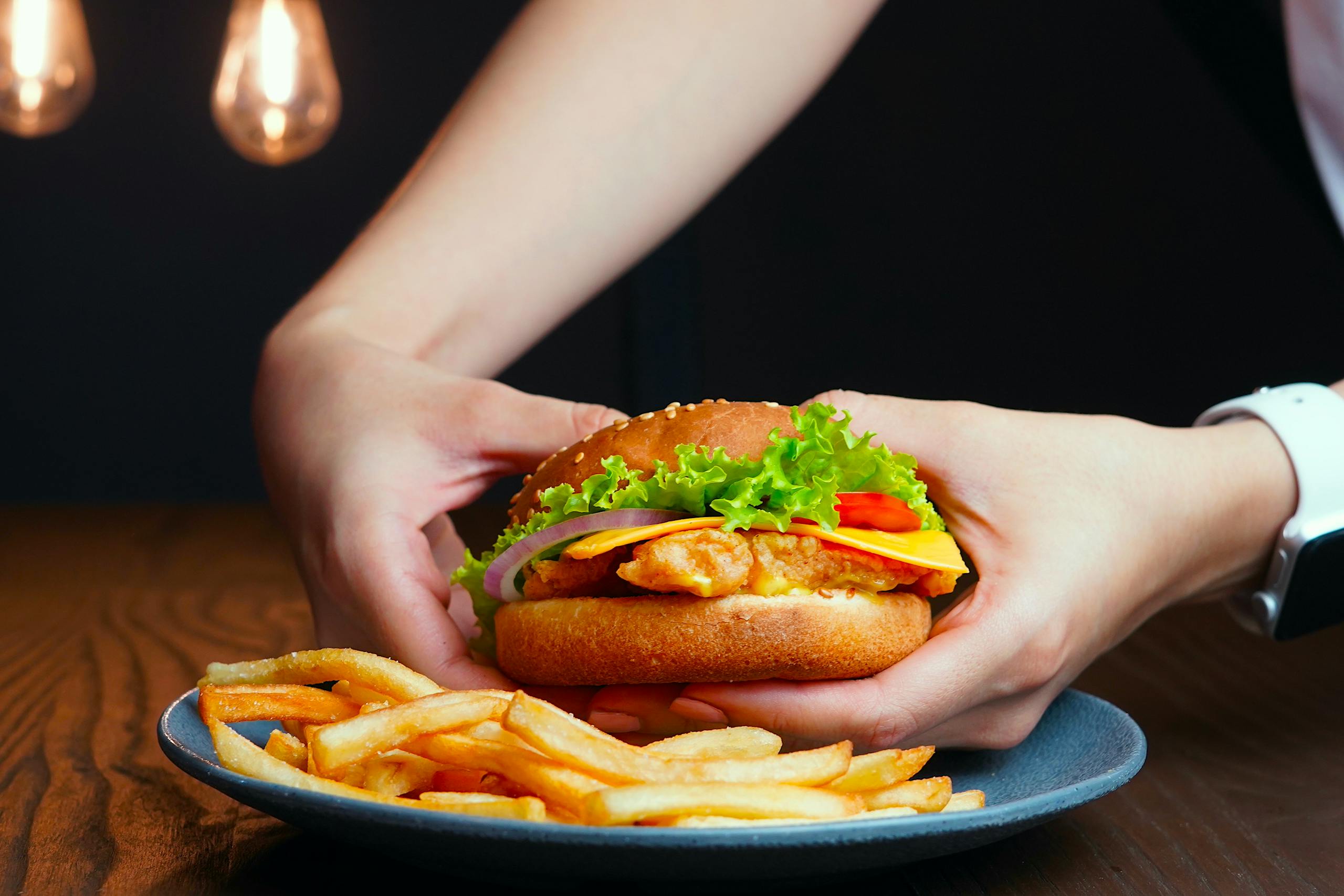 Delicious cheeseburger with lettuce, cheese, and onions served with crispy french fries.