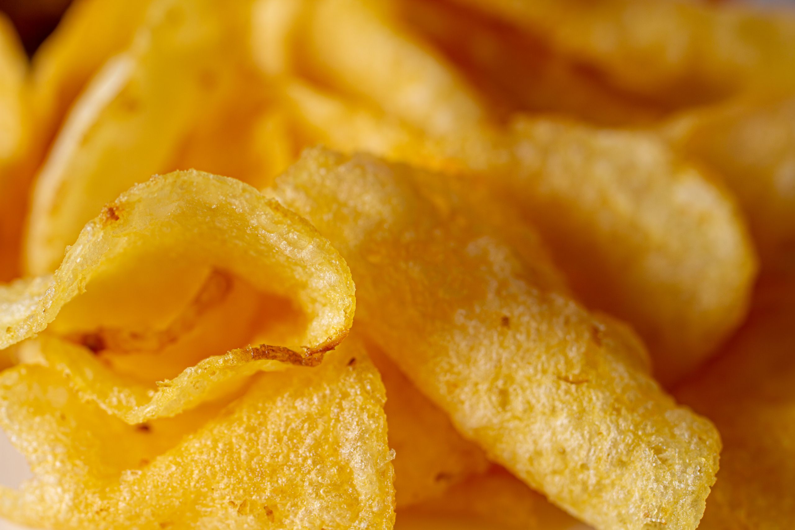 Delicious close-up of crispy golden potato chips, perfect snack option.