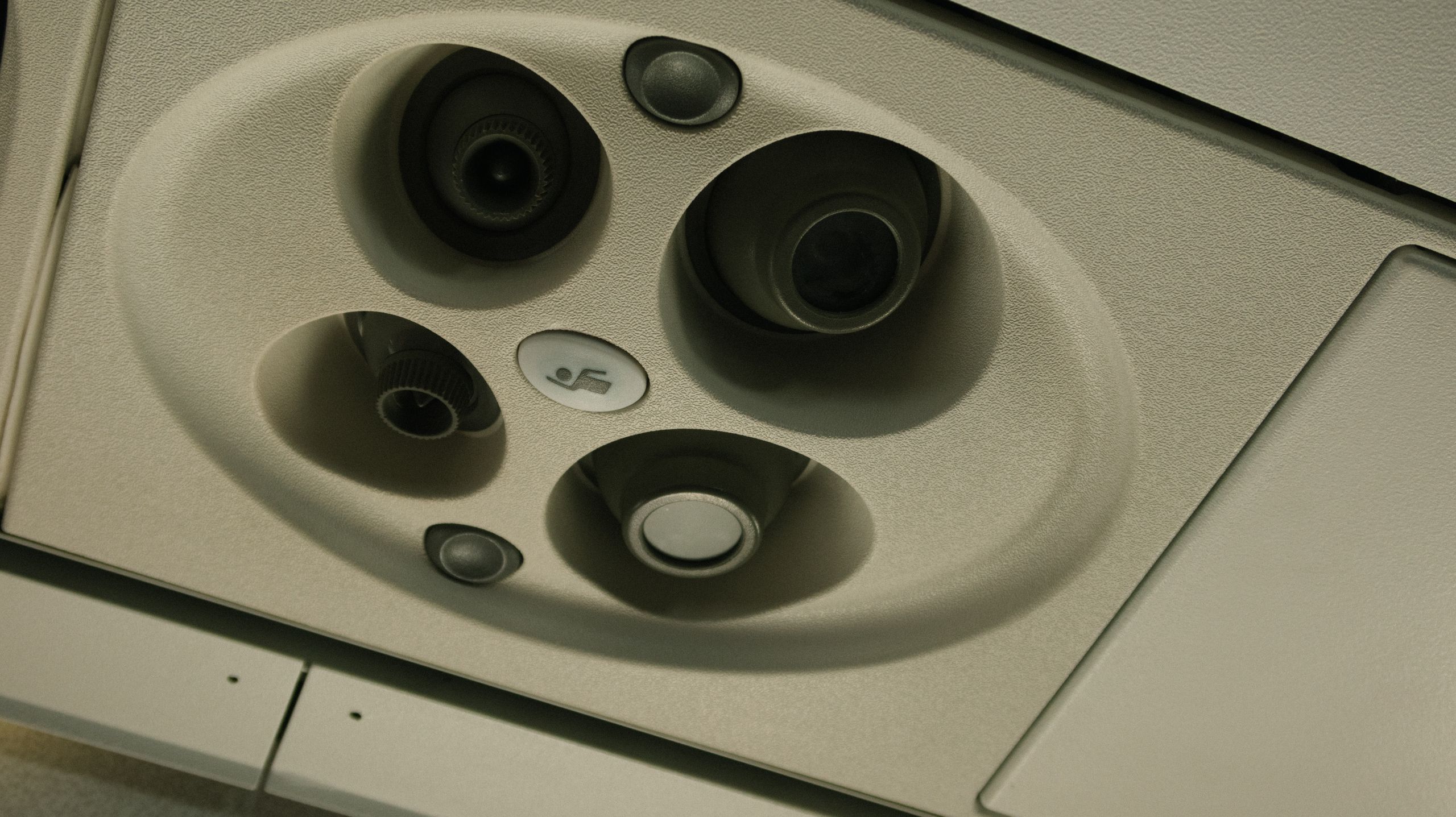 Detailed view of an airplane overhead panel showcasing ventilation and lighting controls.