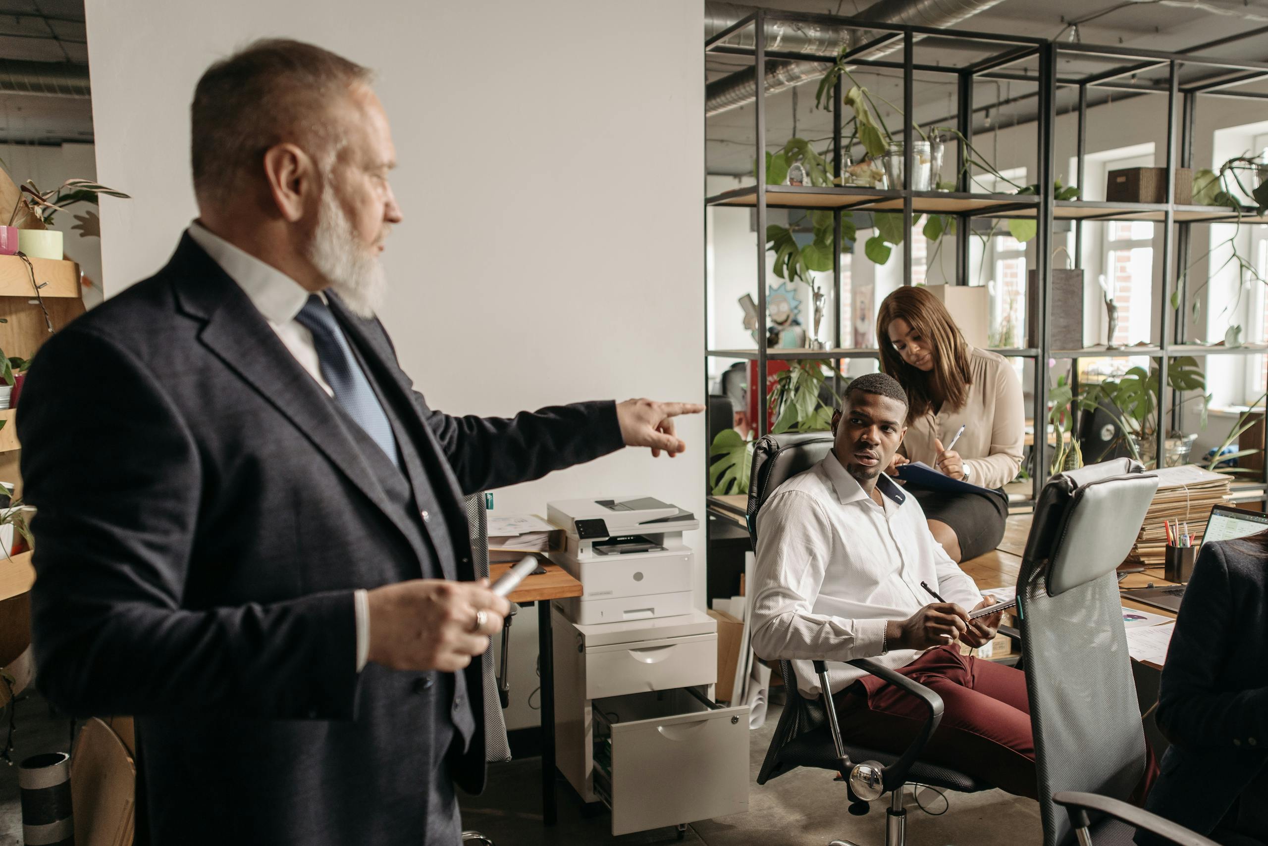 Diverse colleagues engaged in a focused office discussion around a desk.