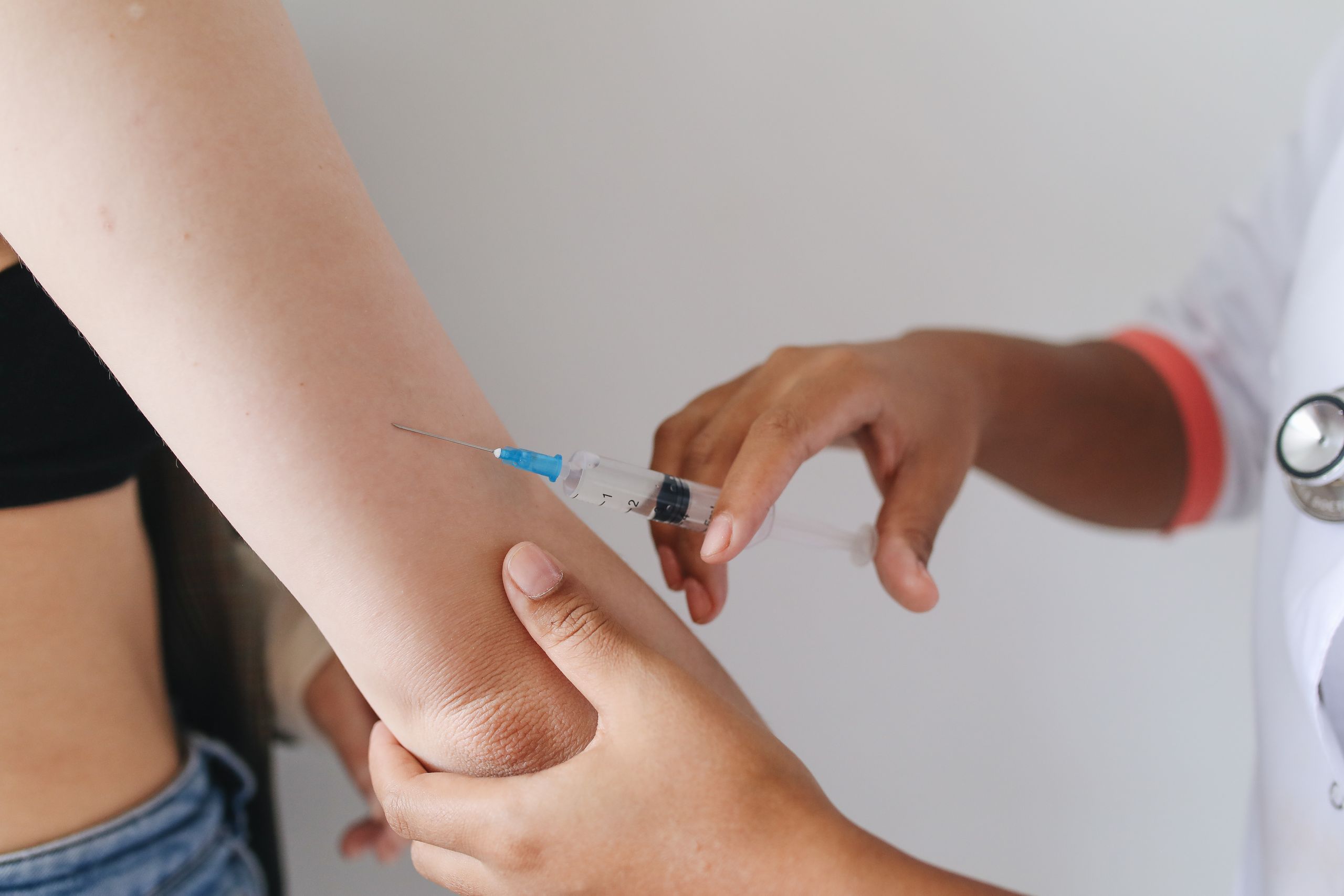 Doctor administering an injection to a patient's arm, close-up view.