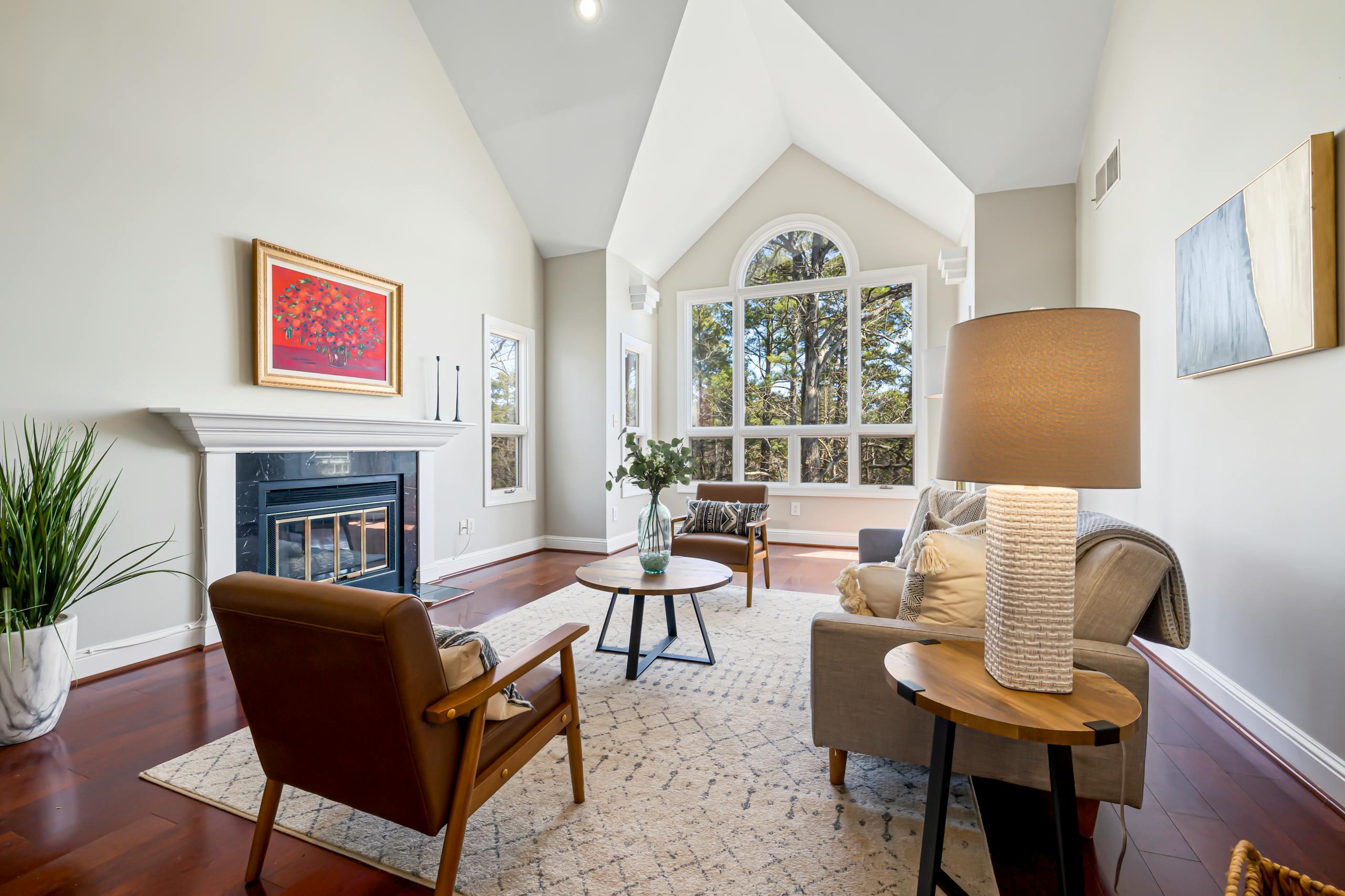 Elegant modern living room featuring a fireplace, high ceilings, and large windows.