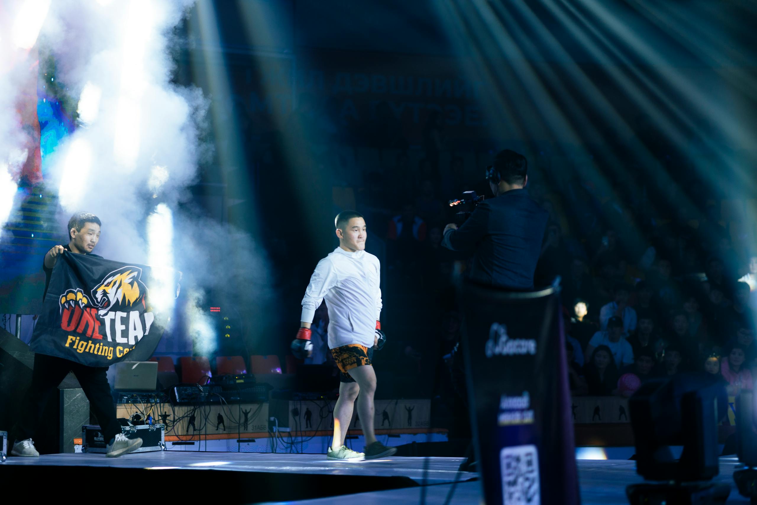 Fighter enters the arena under vibrant lights, creating an electrifying atmosphere for the audience.