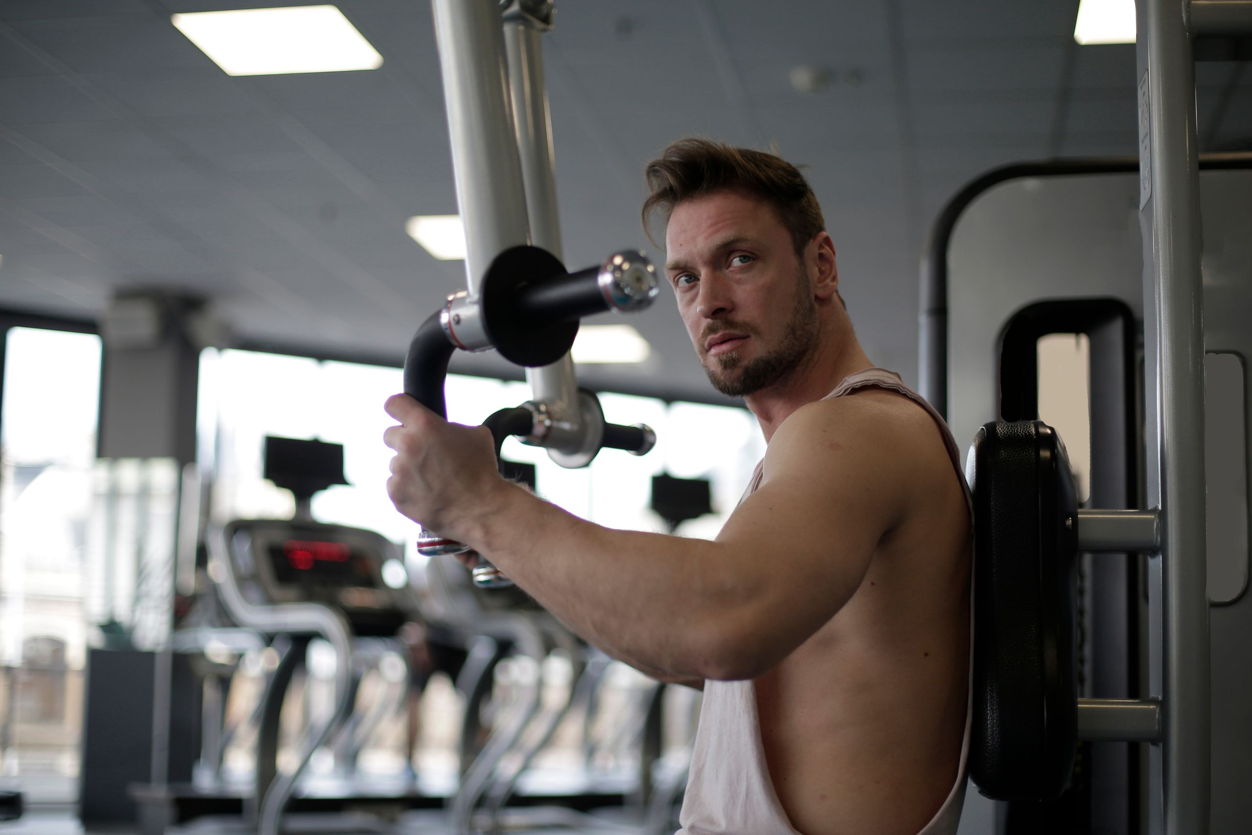 Focused man working out in a gym, showcasing biceps and determination.