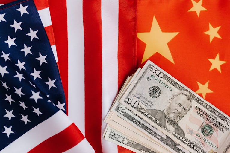 From above of United States banknotes placed on national flags of America and China illustrating international trade concept
