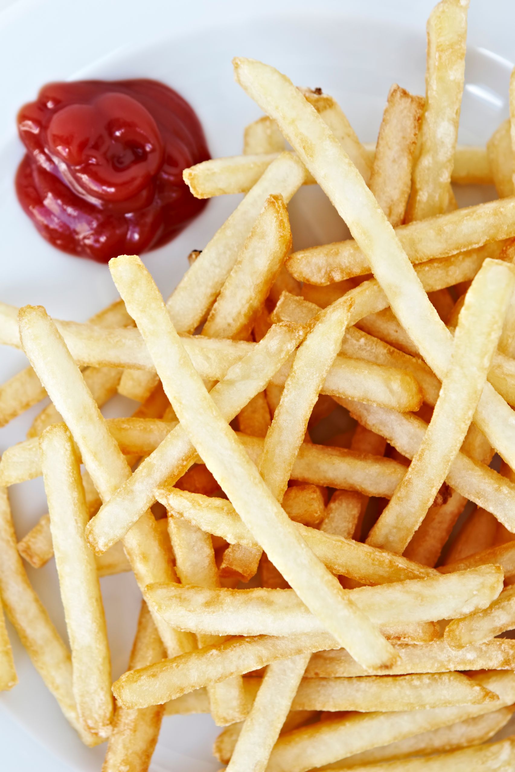 Golden brown French fries served with ketchup, capturing the essence of a tasty fast-food snack.