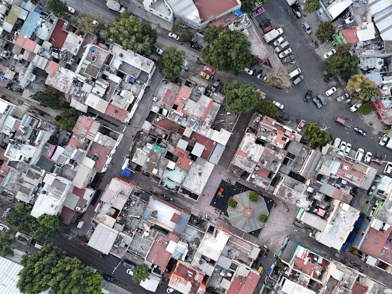 High-angle shot of densely packed urban residential area with streets and vehicles.