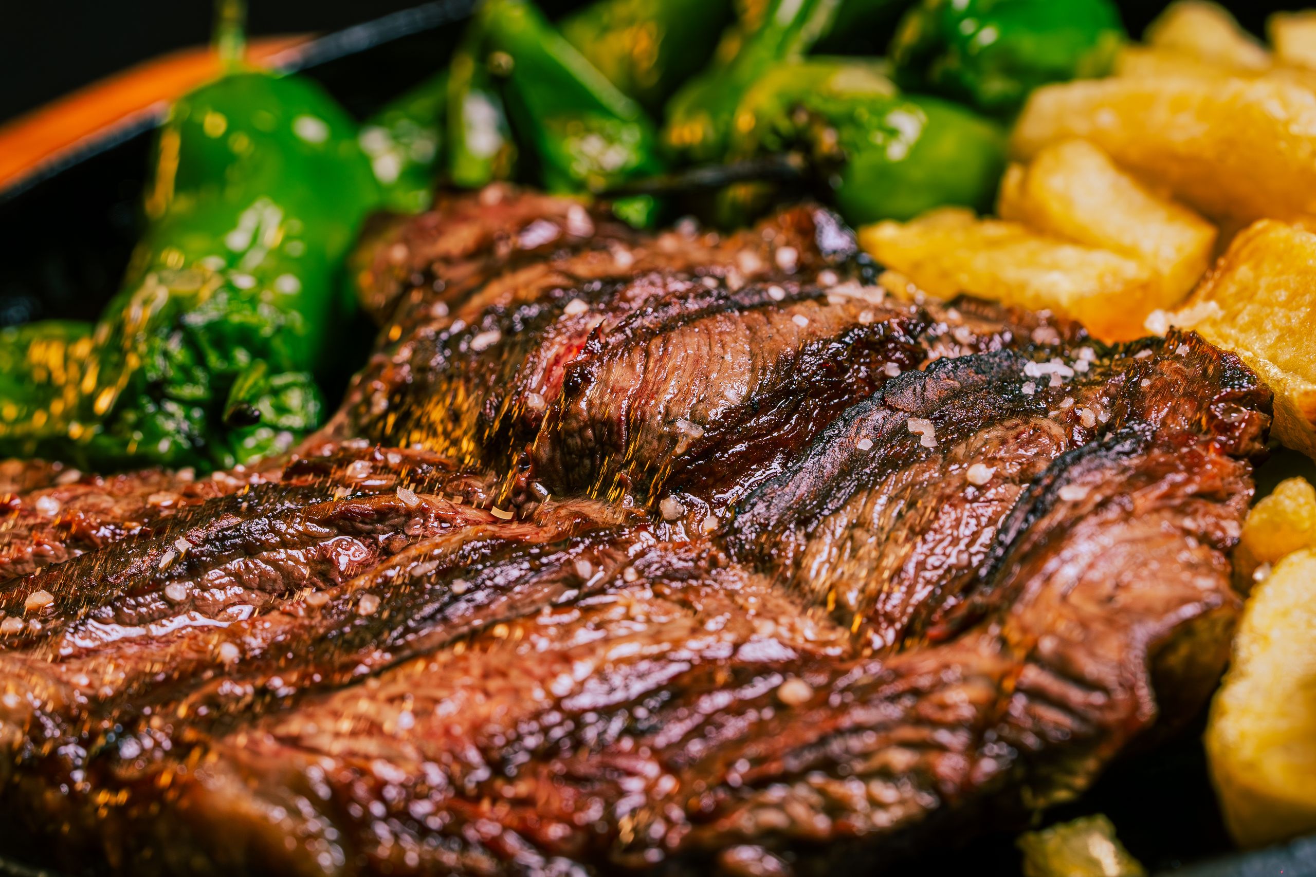 Juicy grilled beef steak served with green peppers and crispy fries.