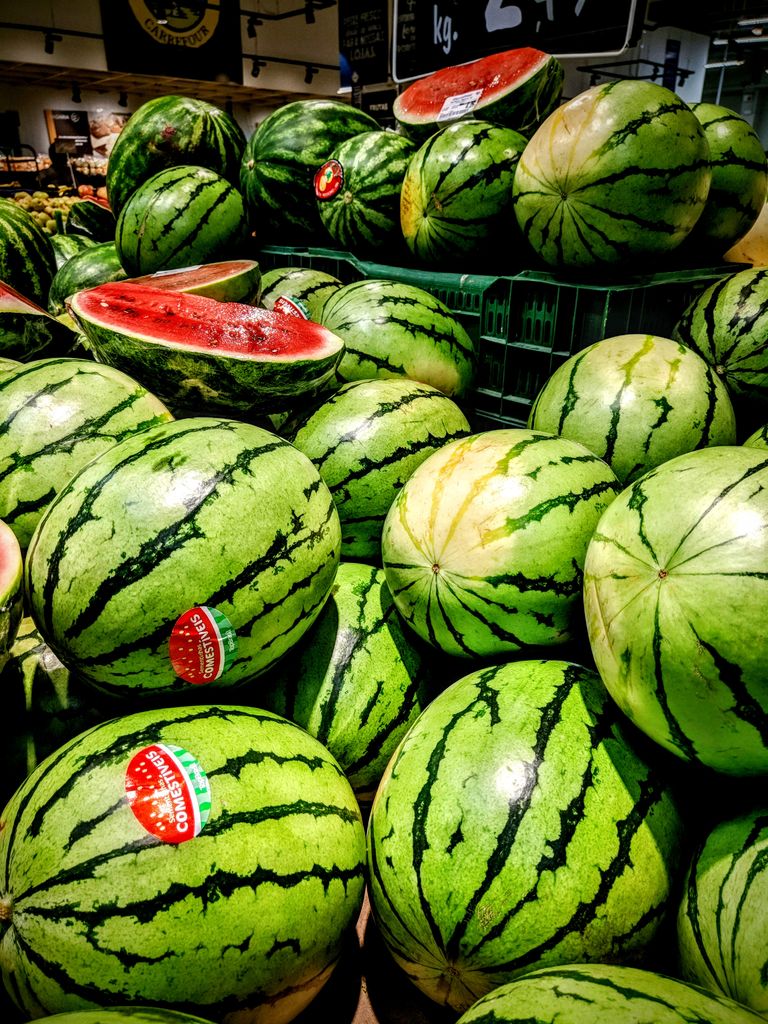 Juicy, sliced watermelons in a plastic crate, showcasing freshness at a market.