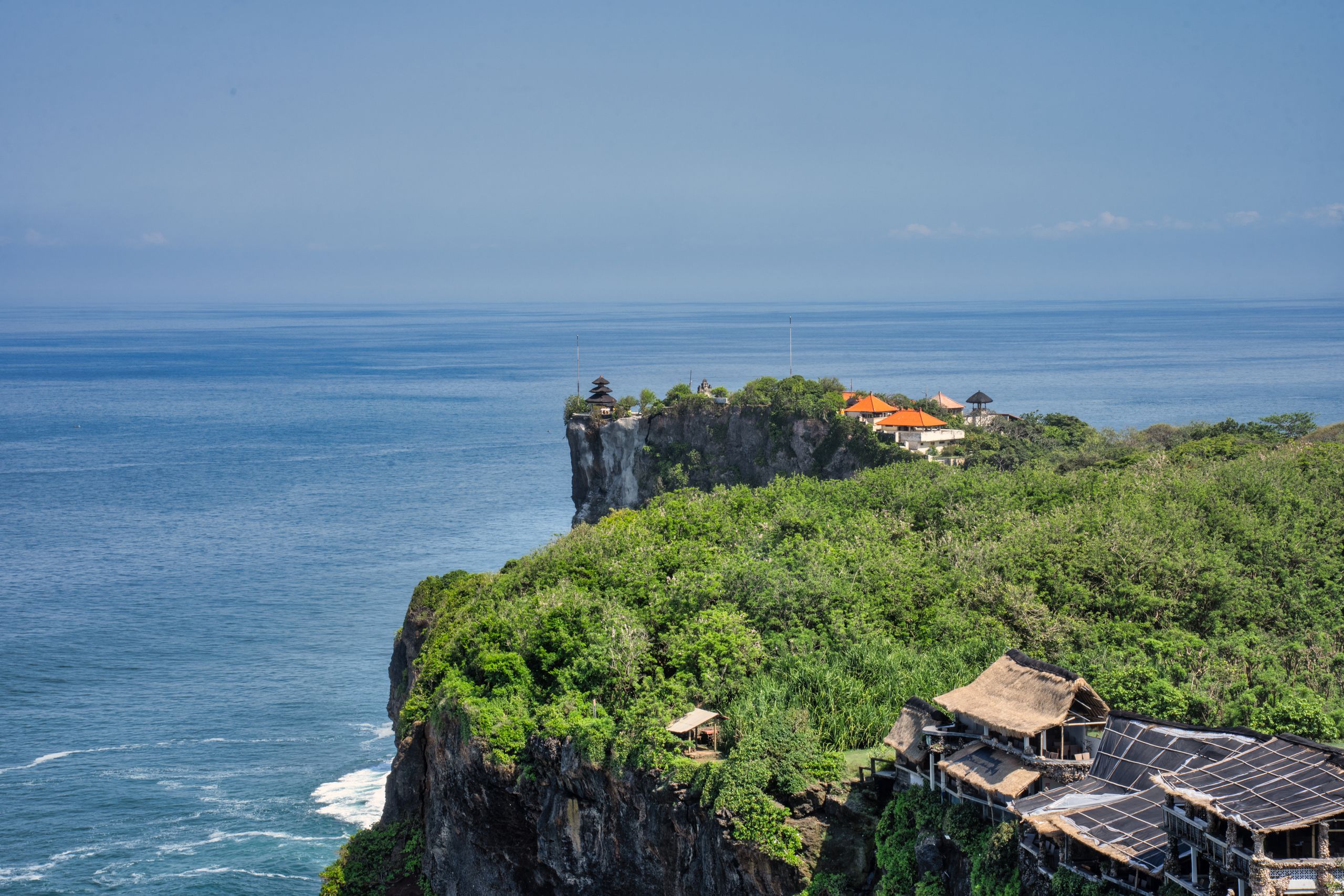 Majestic cliffside views overlooking the sea in Bali, highlighting lush greenery and architecture.