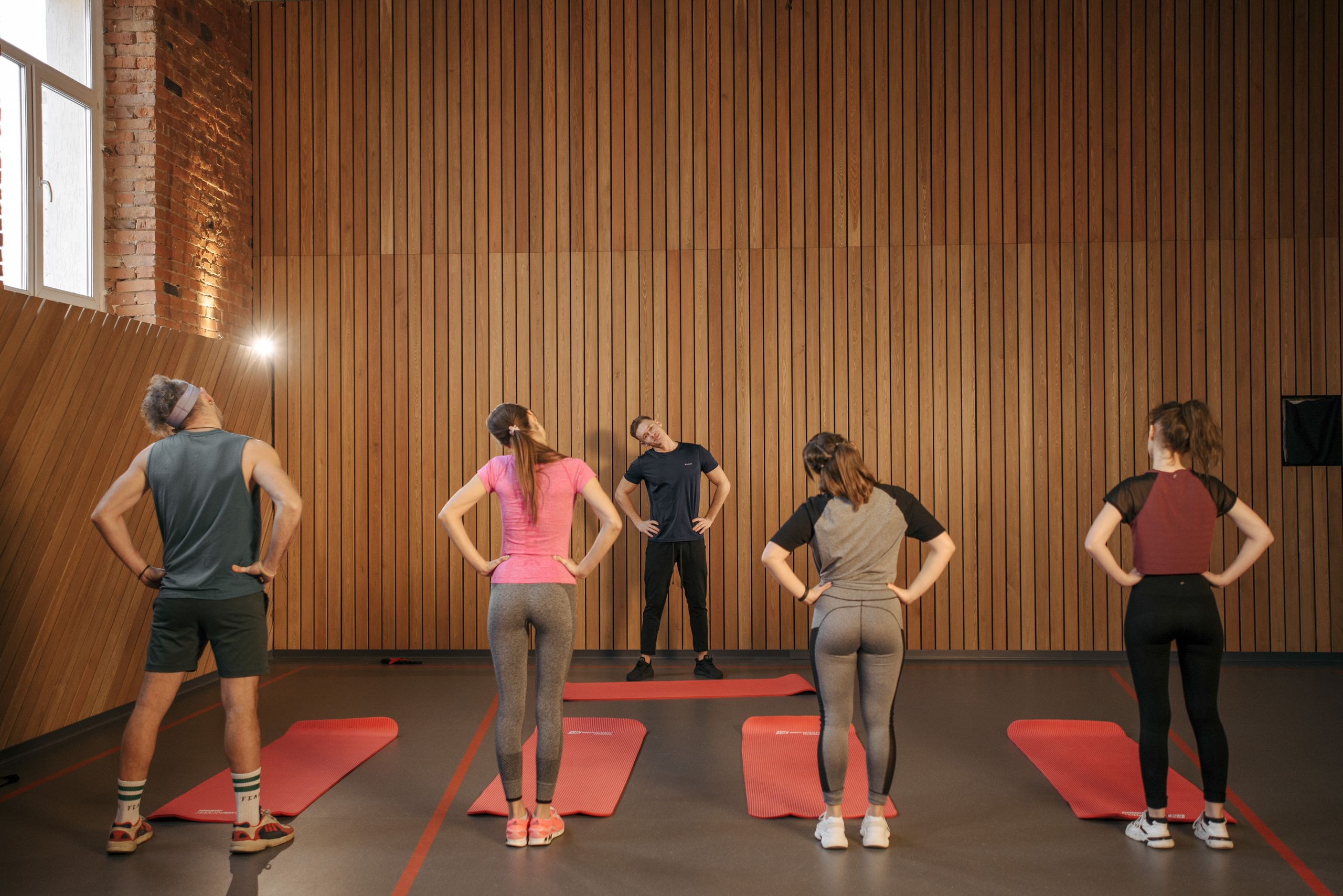 Men and women performing stretching exercises on mats in a fitness class