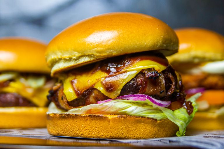 Mouthwatering beef burger topped with cheddar and onions, ideal for food lovers.