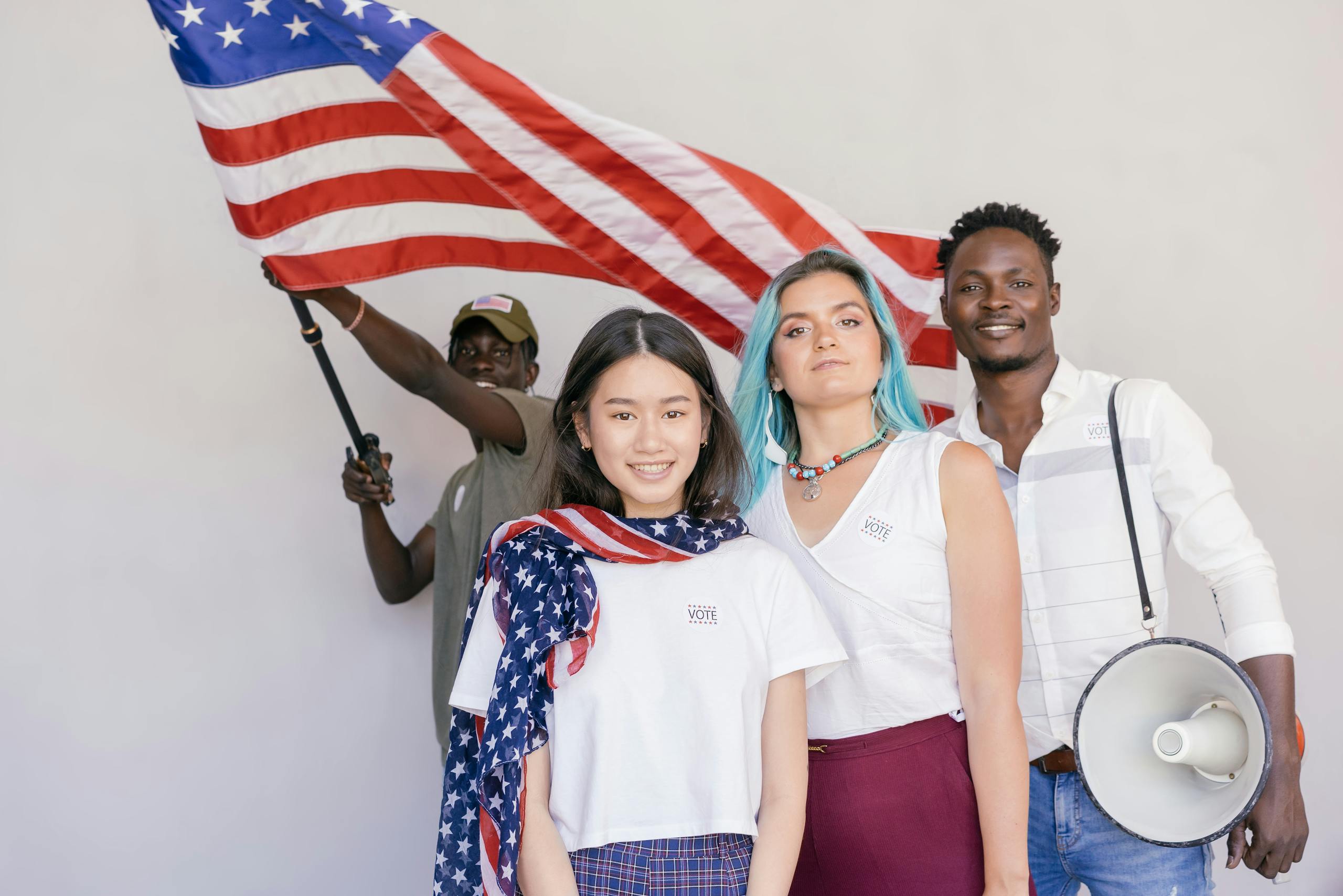 Multiracial group celebrating with the American flag, promoting unity and patriotism.