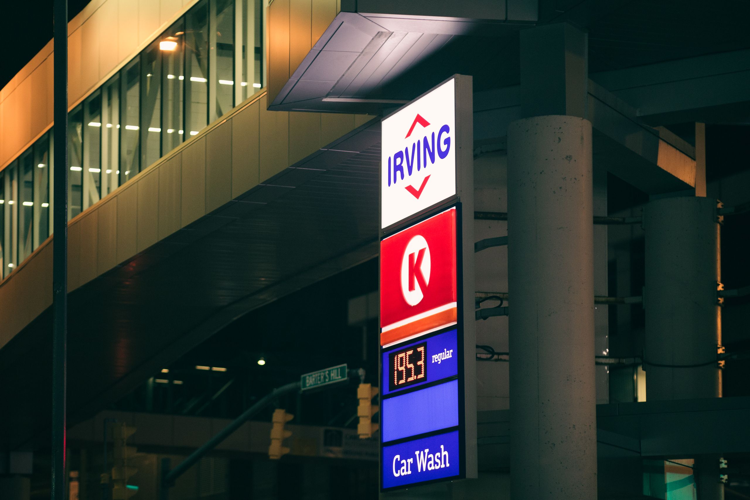 Night view of an illuminated Irving street sign and subway entrance in an urban area.