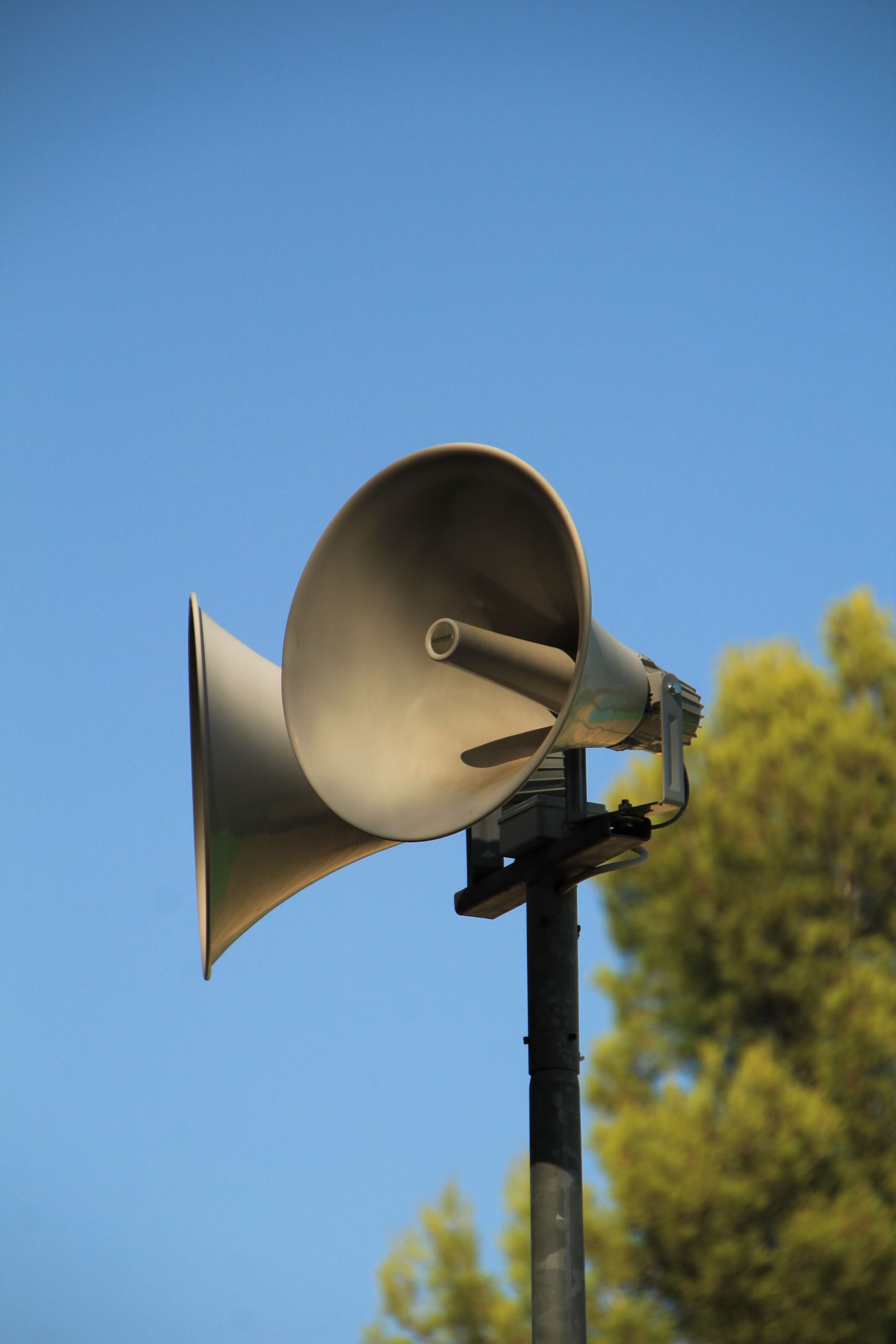 Outdoor megaphone against a clear blue sky for public announcements.