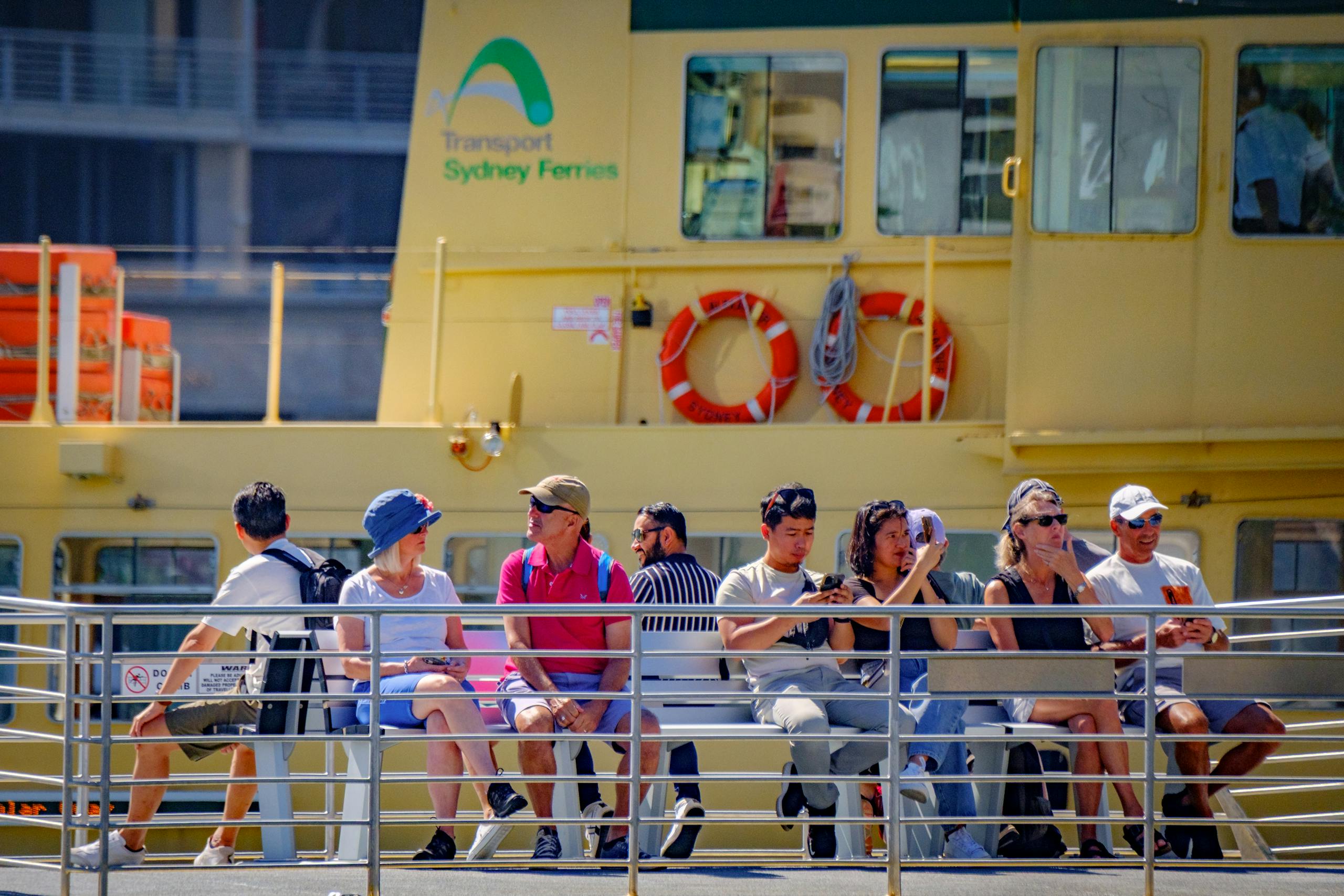 Passengers aboard Sydney Ferry enjoy a sunny day, showcasing leisure and travel.