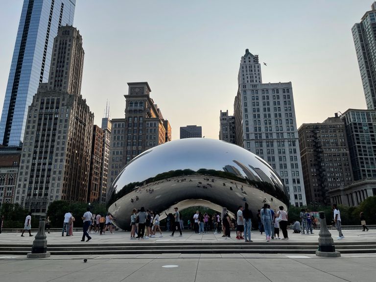 People gathered around Cloud Gate, a famous landmark in downtown Chicago.