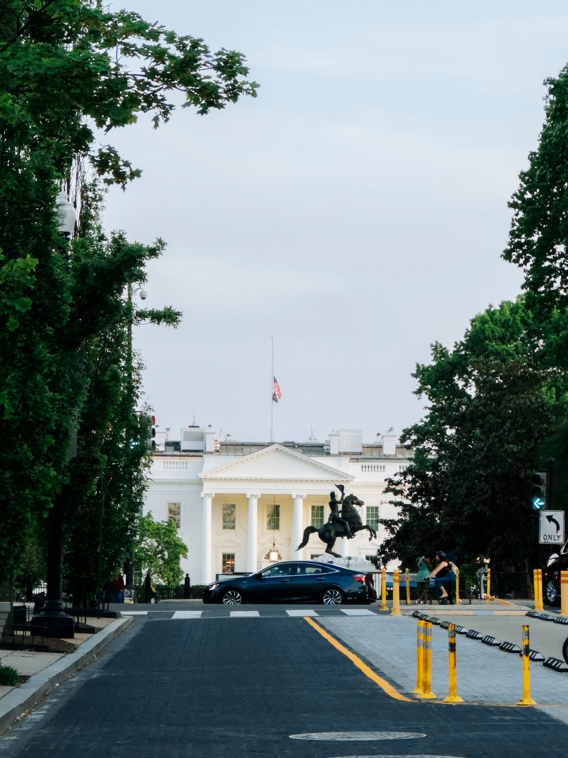 Photograph of the White House from Lafayette Square, showcasing historic architecture and vibrant greenery.