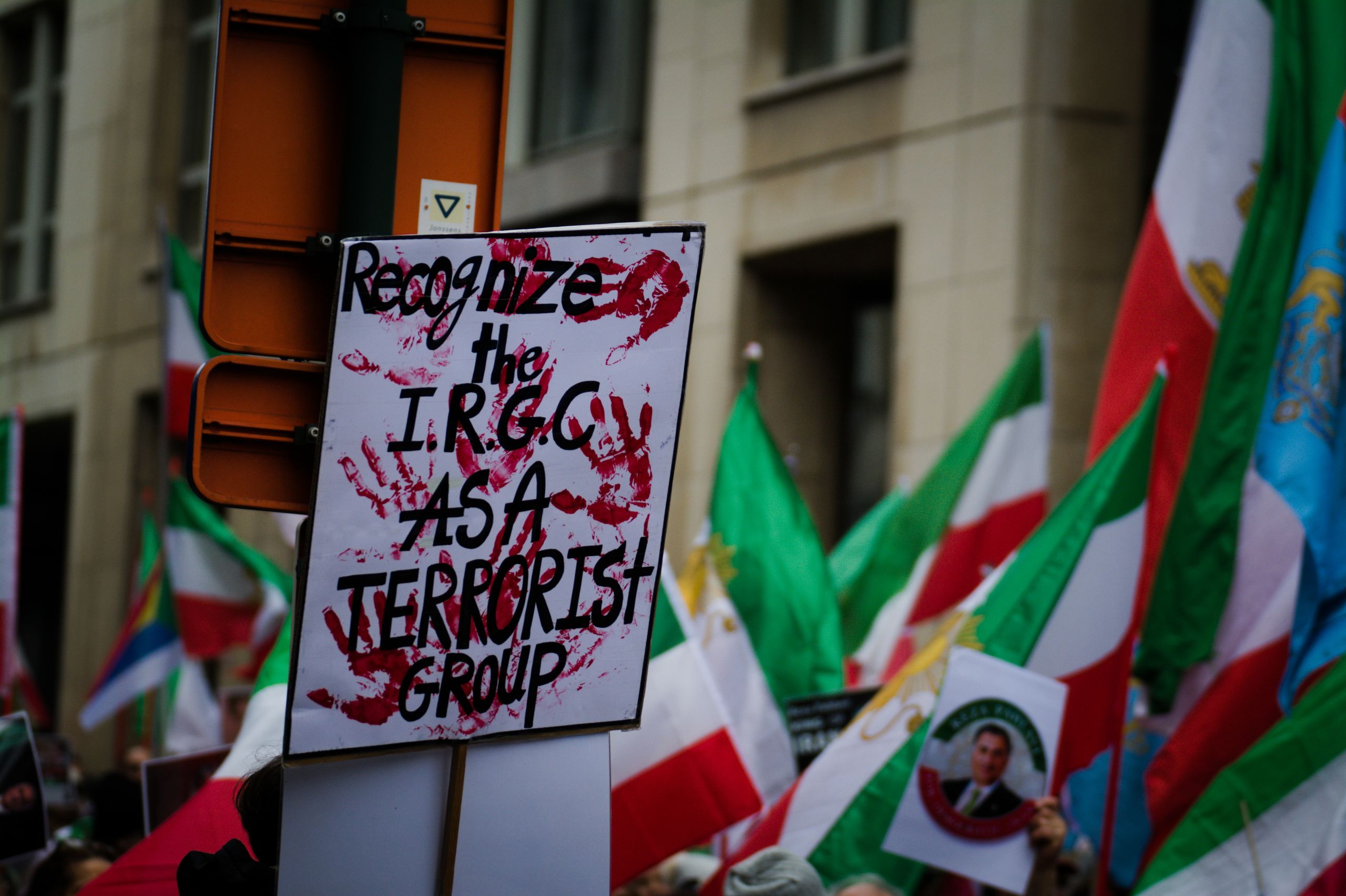 Protest in Brussels with flags and signs demanding IRGC recognition as a terrorist group.