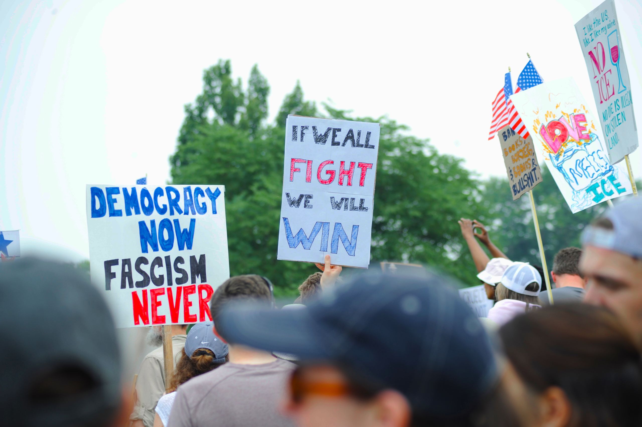 Protesters gather with signs advocating democracy and rejecting fascism at a rally in Baltimore.
