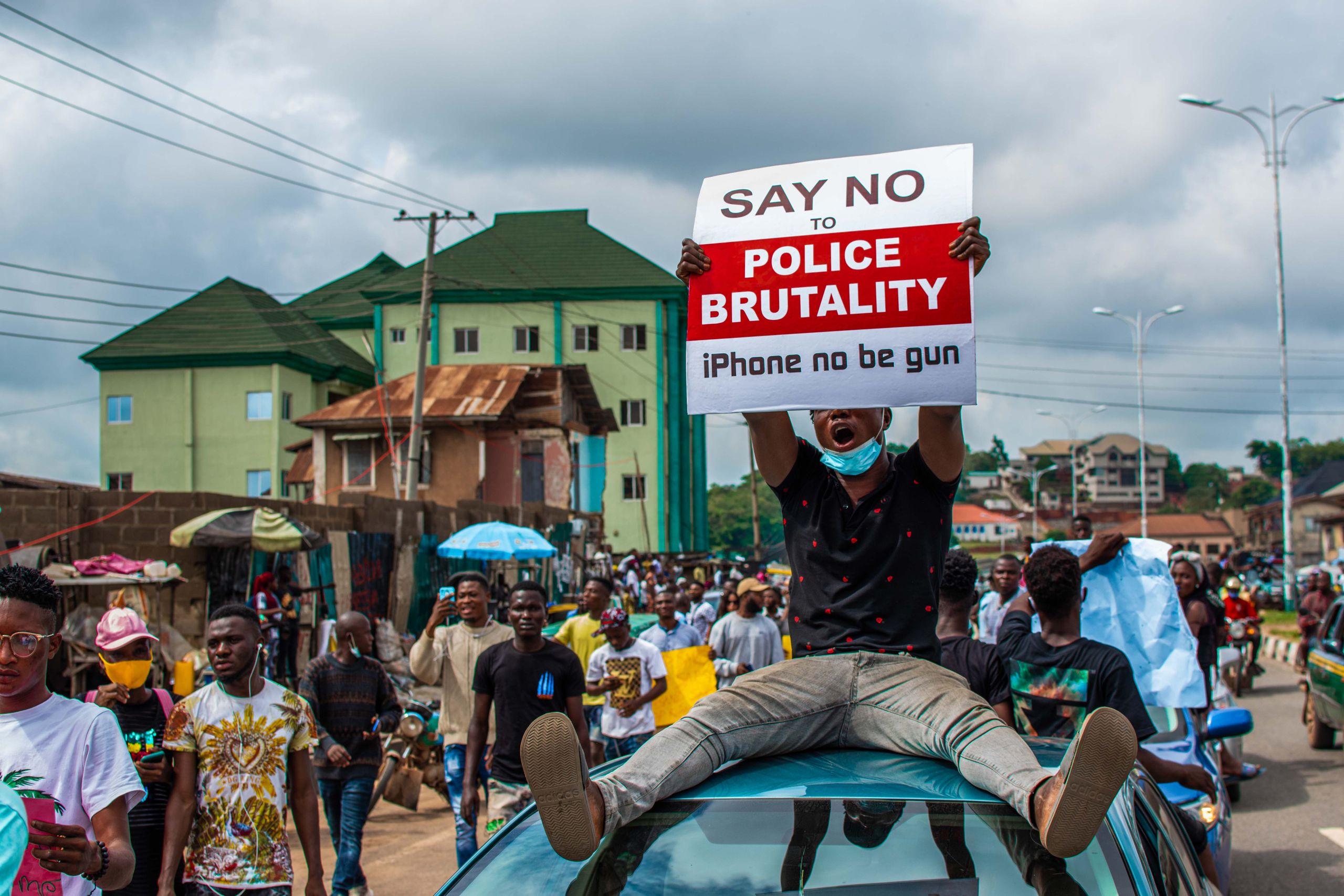 Protesters rally in the streets holding signs against police brutality, highlighting urban activism.