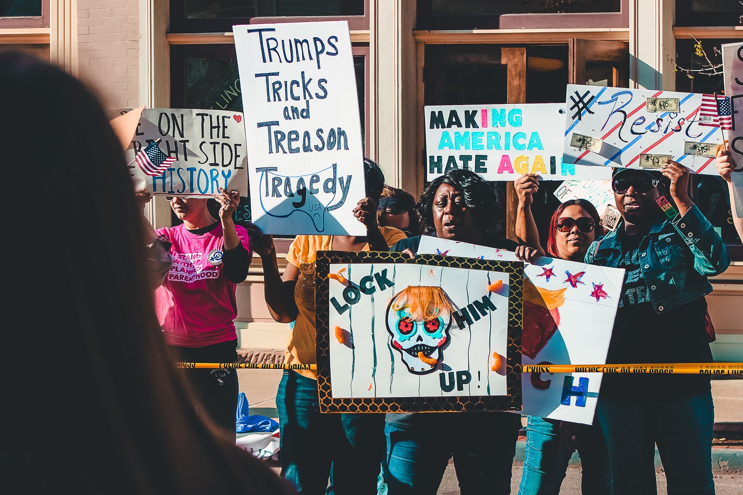 Protesters rally on Wheeling streets holding political signs and banners in a vibrant demonstration.