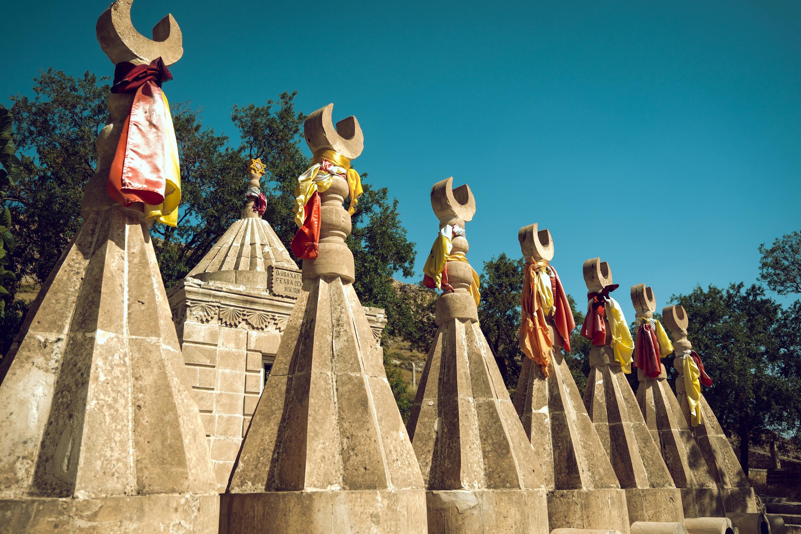 Sacred Yazidi sculptures adorned with colorful fabric in Mağarak&ouml;y, Şırnak, T&uuml;rkiye.