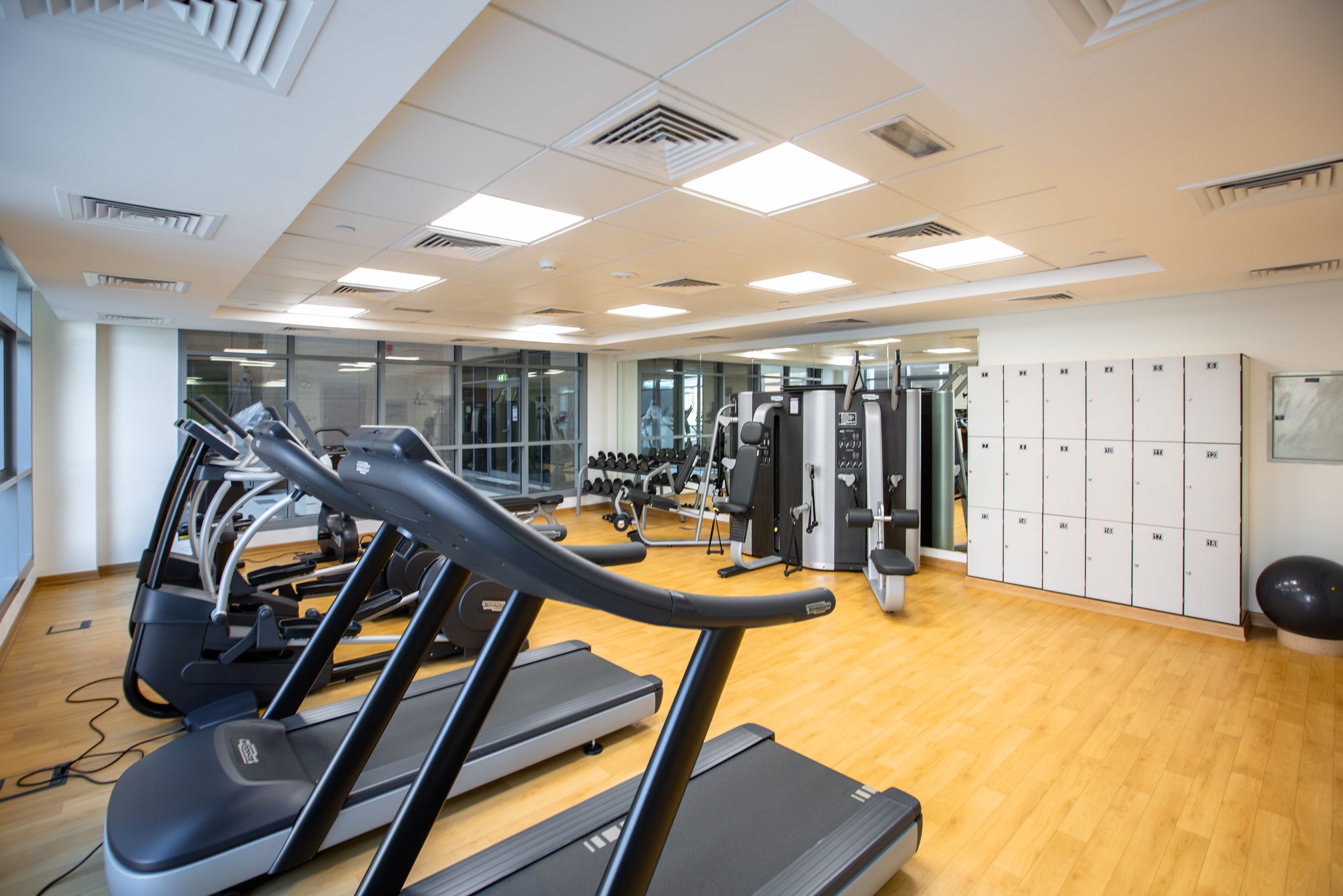 Spacious gym interior featuring treadmills, fitness machines, and lockers.