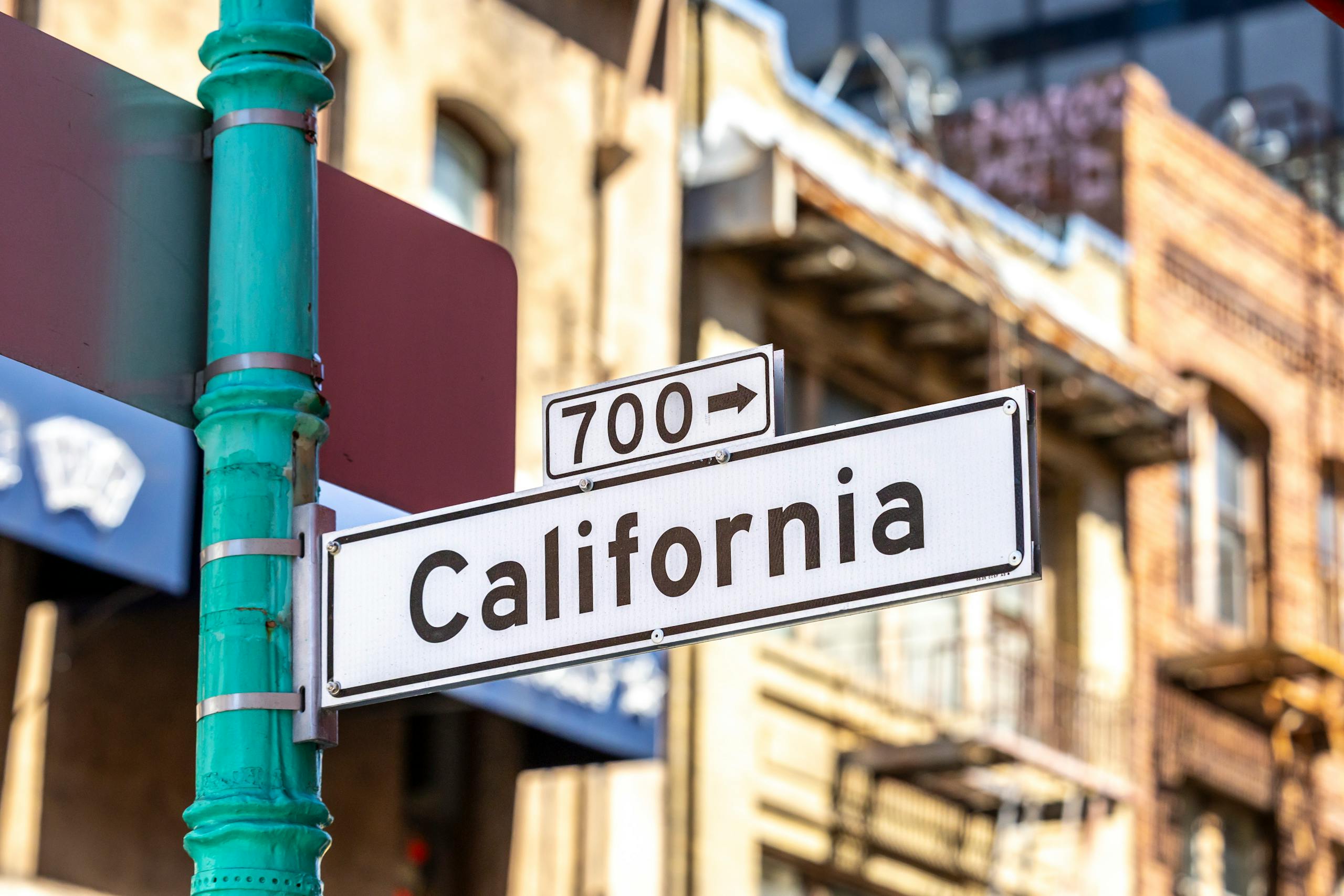 Street sign for California in an urban environment, highlighting city life.
