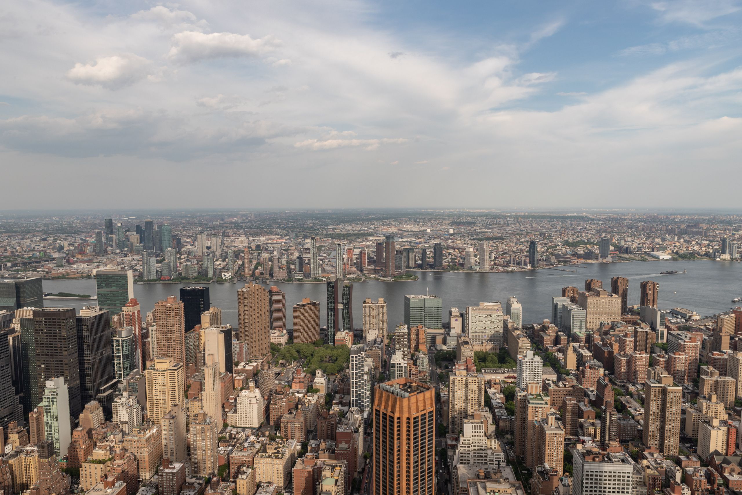 Stunning aerial view of New York City's Manhattan skyline with the East River in the background, showcasing urban architecture.
