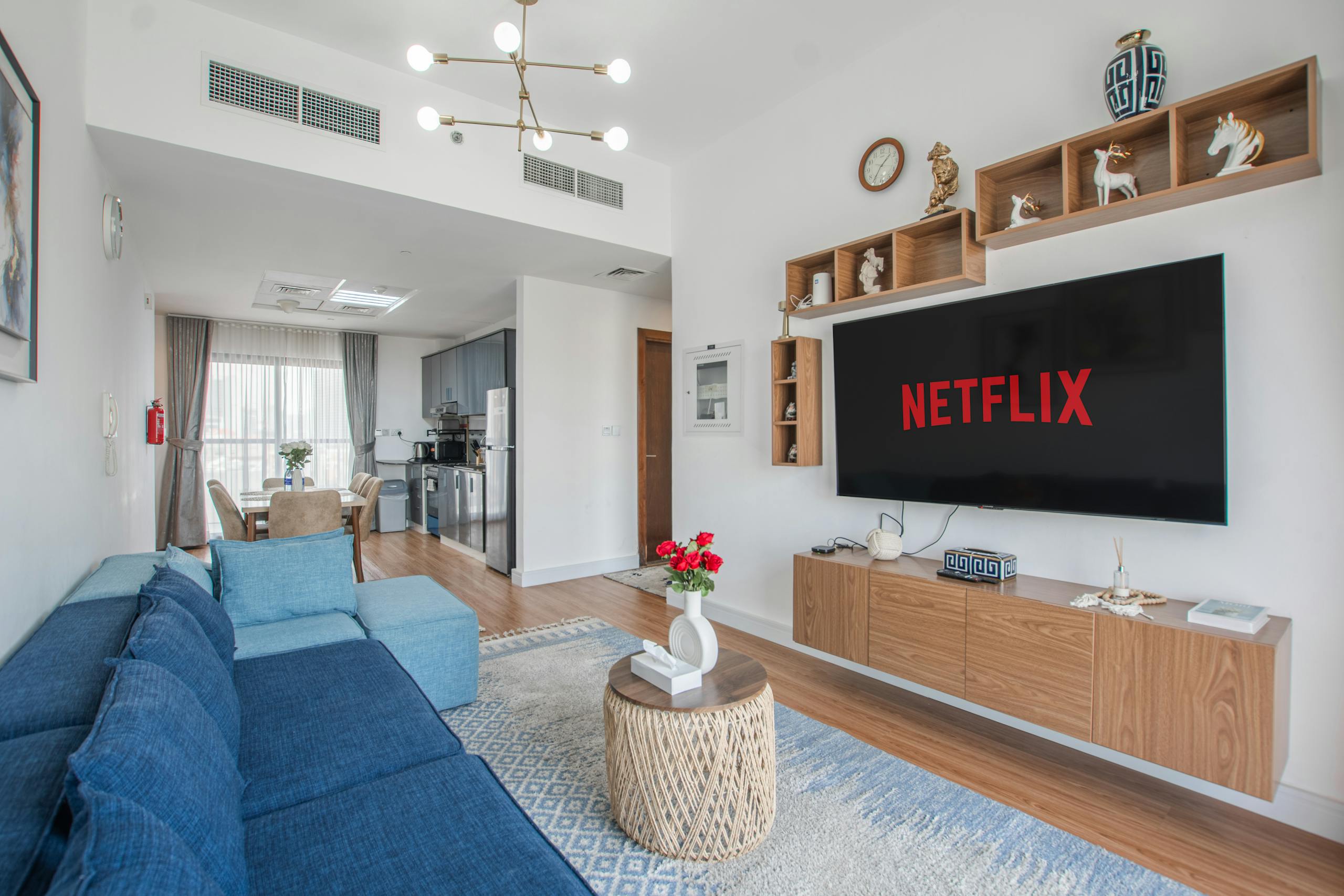 Stylish modern living space with TV displaying Netflix and cozy blue sofa.
