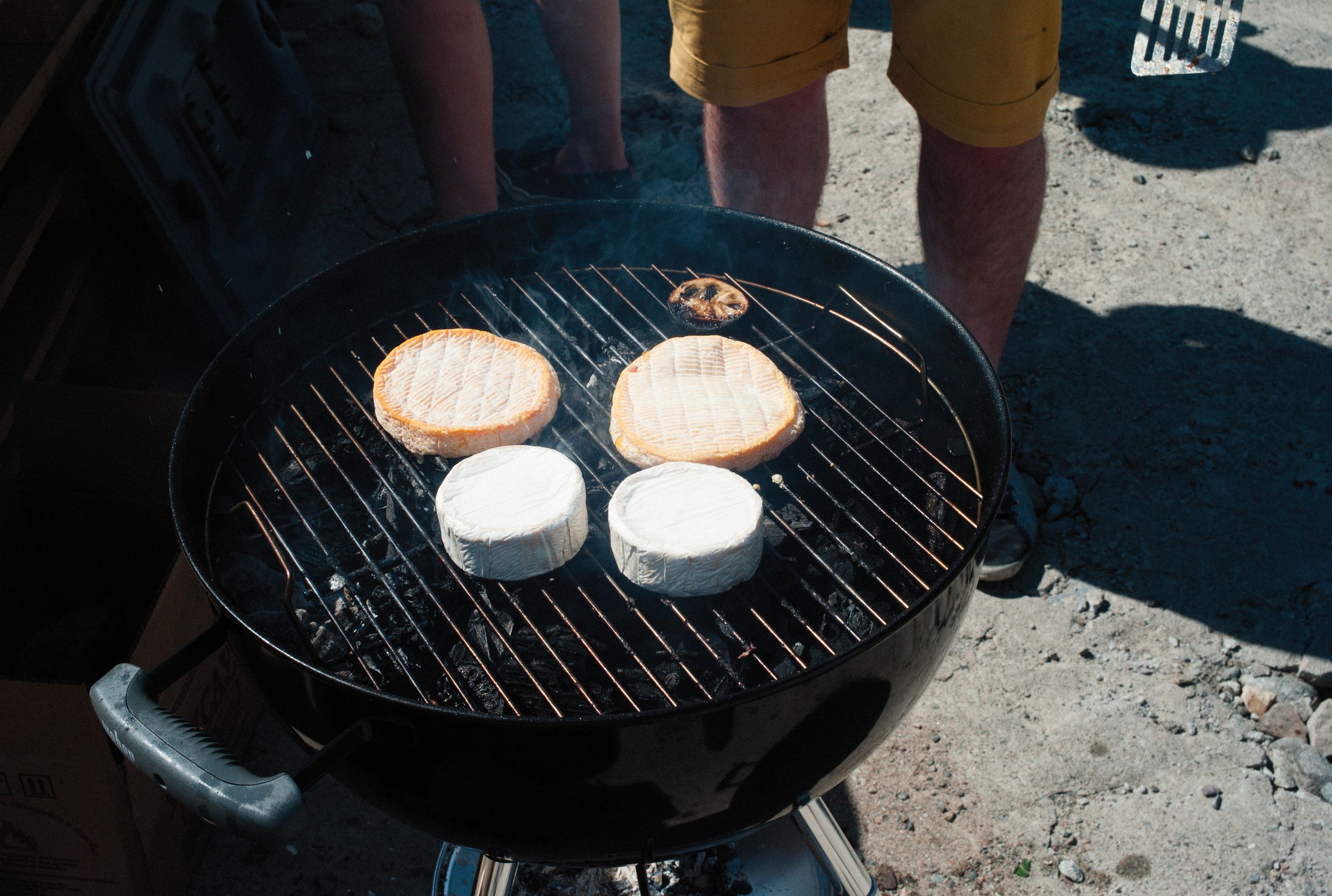 Succulent cheeses being grilled on a charcoal barbecue, perfect for outdoor gatherings.