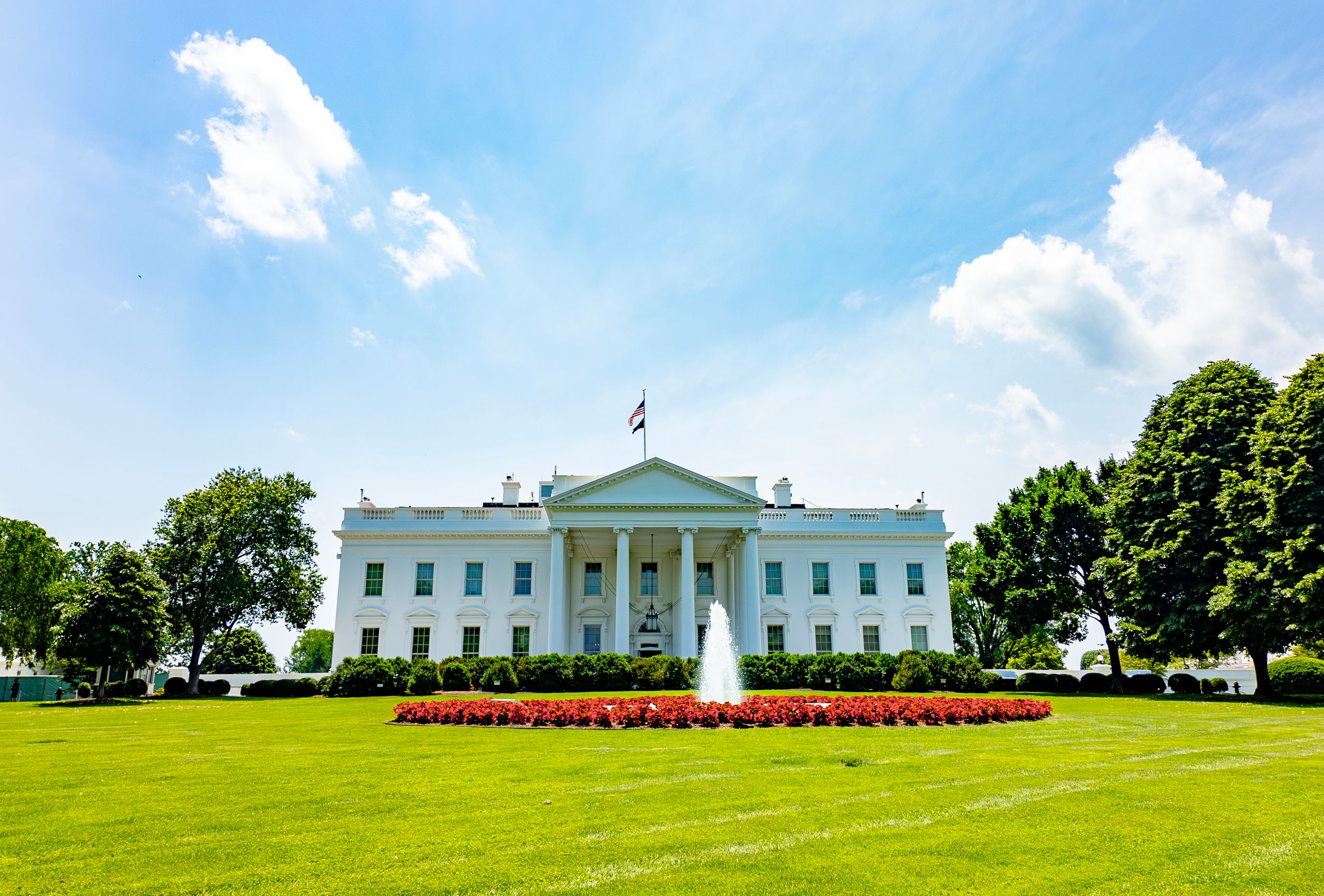 The iconic White House lawn and fountain on a bright summer day in Washington, DC.