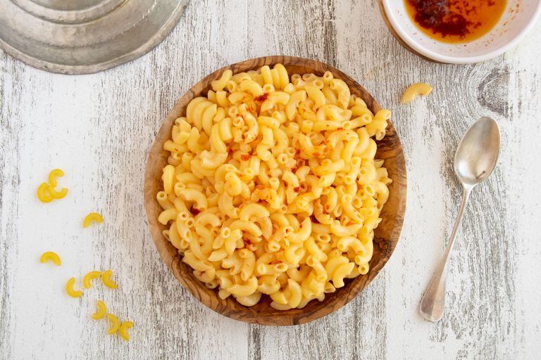 Top view of a bowl of creamy macaroni and cheese on a rustic table.