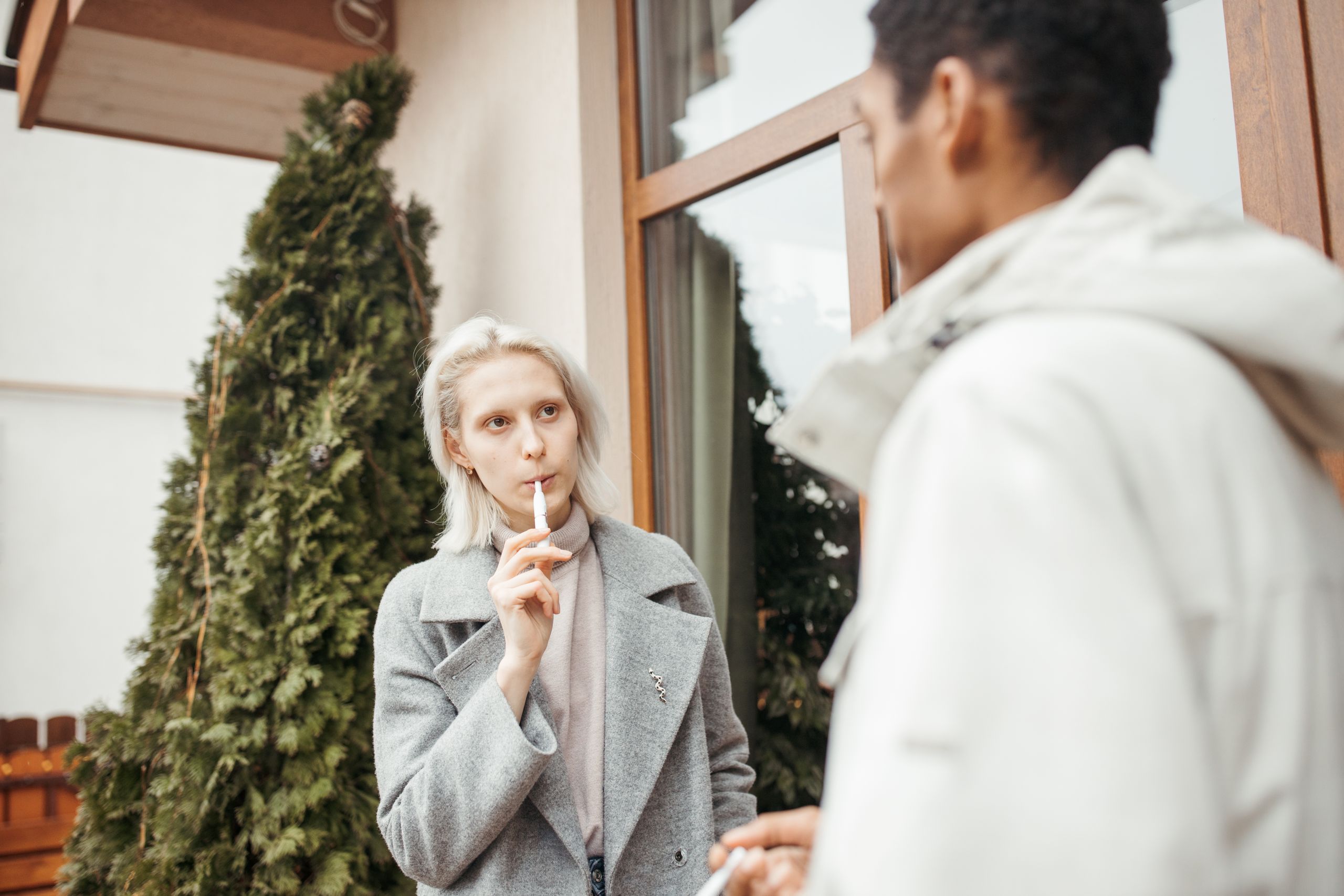 Two colleagues conversing outdoors in a relaxed setting, reflecting teamwork and diversity.