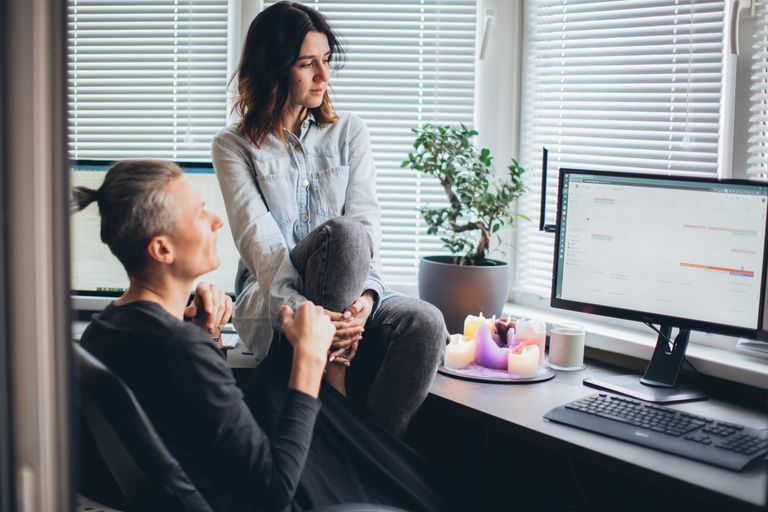 Two people in a home office setting having a discussion about a project, exuding a relaxed and collaborative atmosphere.