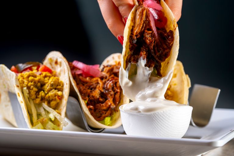 Vibrant tacos with mouthwatering fillings, served with creamy sauce. Perfect for food presentations.
