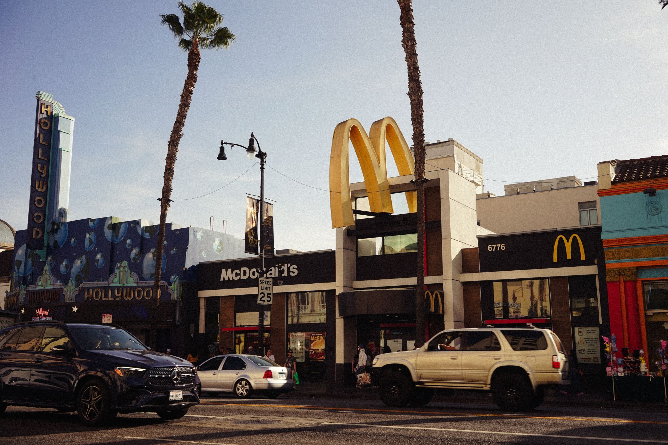 View of McDonald's and Hollywood buildings in Los Angeles, vibrant urban street life captured.