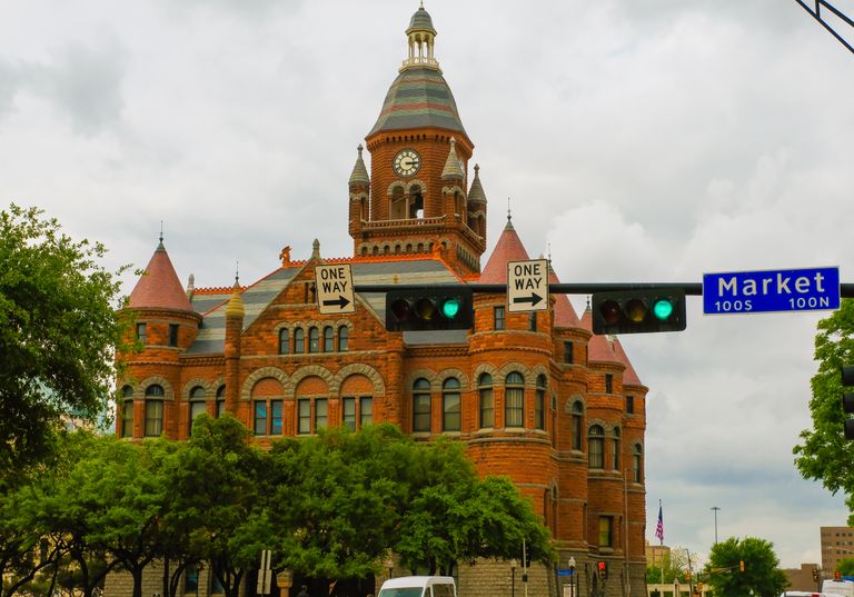 View of the iconic Dallas County Courthouse with its red brick facade and clock tower, capturing historic architecture.