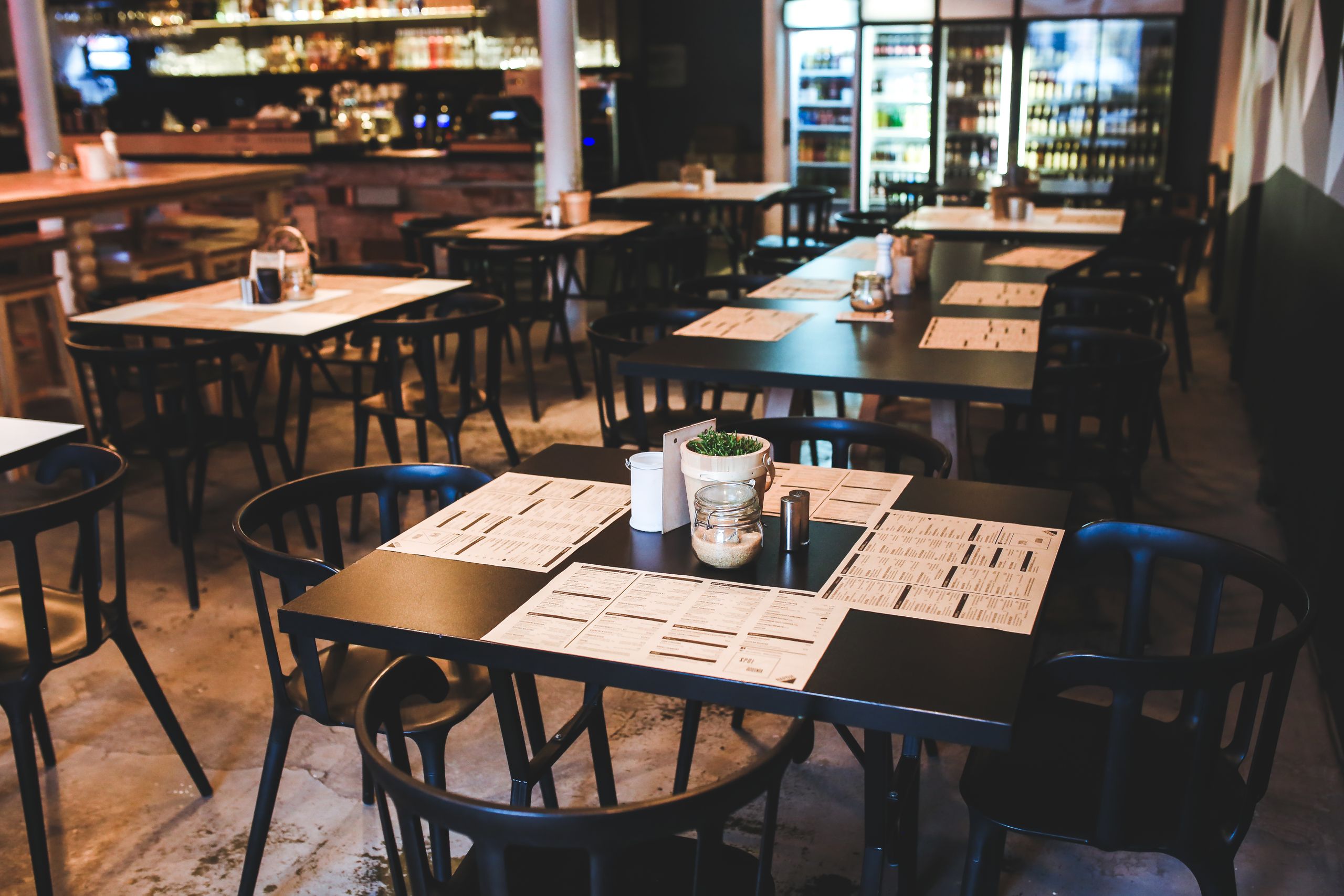 Warm and inviting caf&eacute; with tables, chairs, and a cozy ambiance.