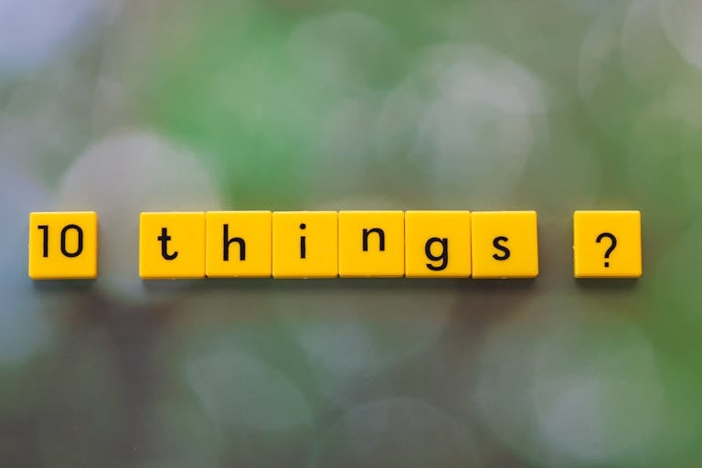 Yellow tiles spelling '10 things?' on a green blurred background.