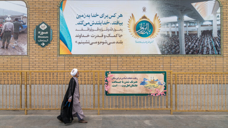 Qom, Iran - May 2019: Iranian man walking a street in Qom, which is considered by Shia Muslims to be the second most sacred city in Iran.